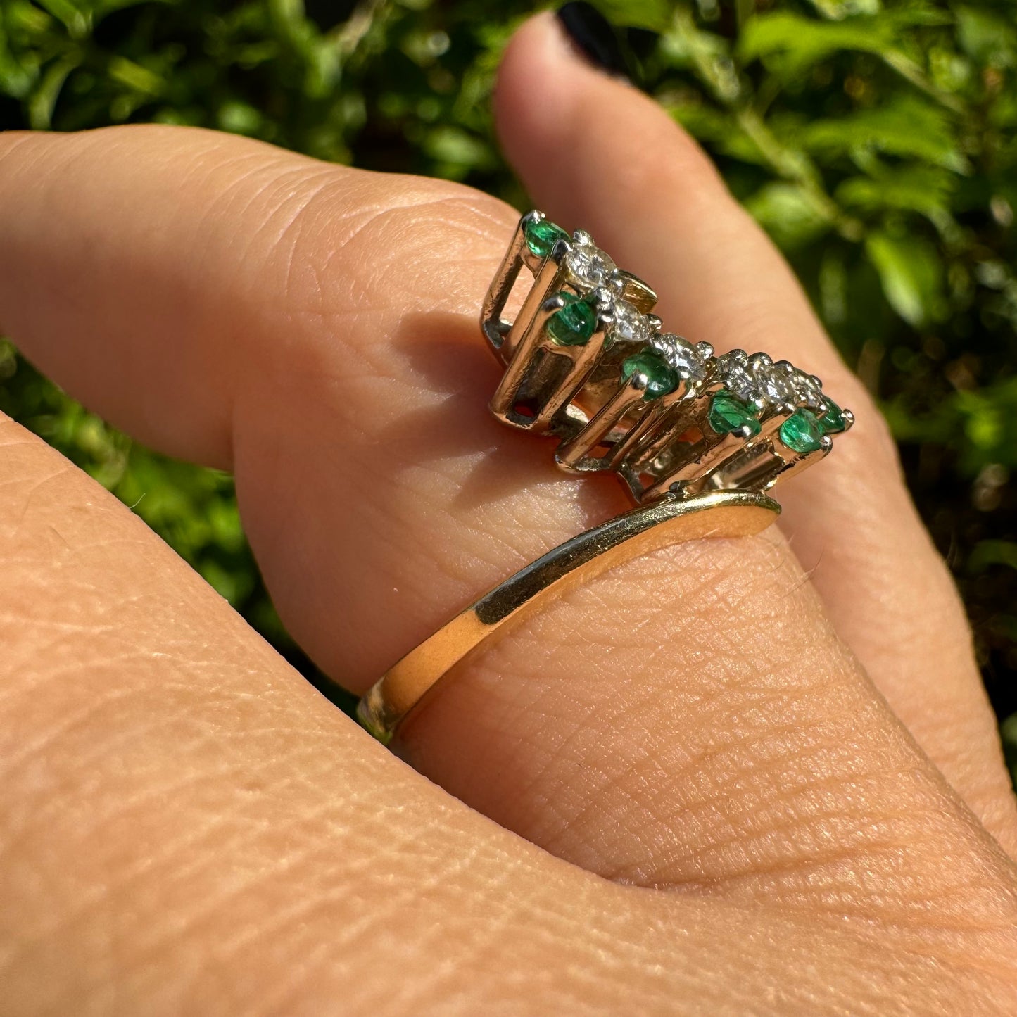 14K gold open ring featuring a delicate swirl set with Emeralds and brilliant-cut Diamonds
