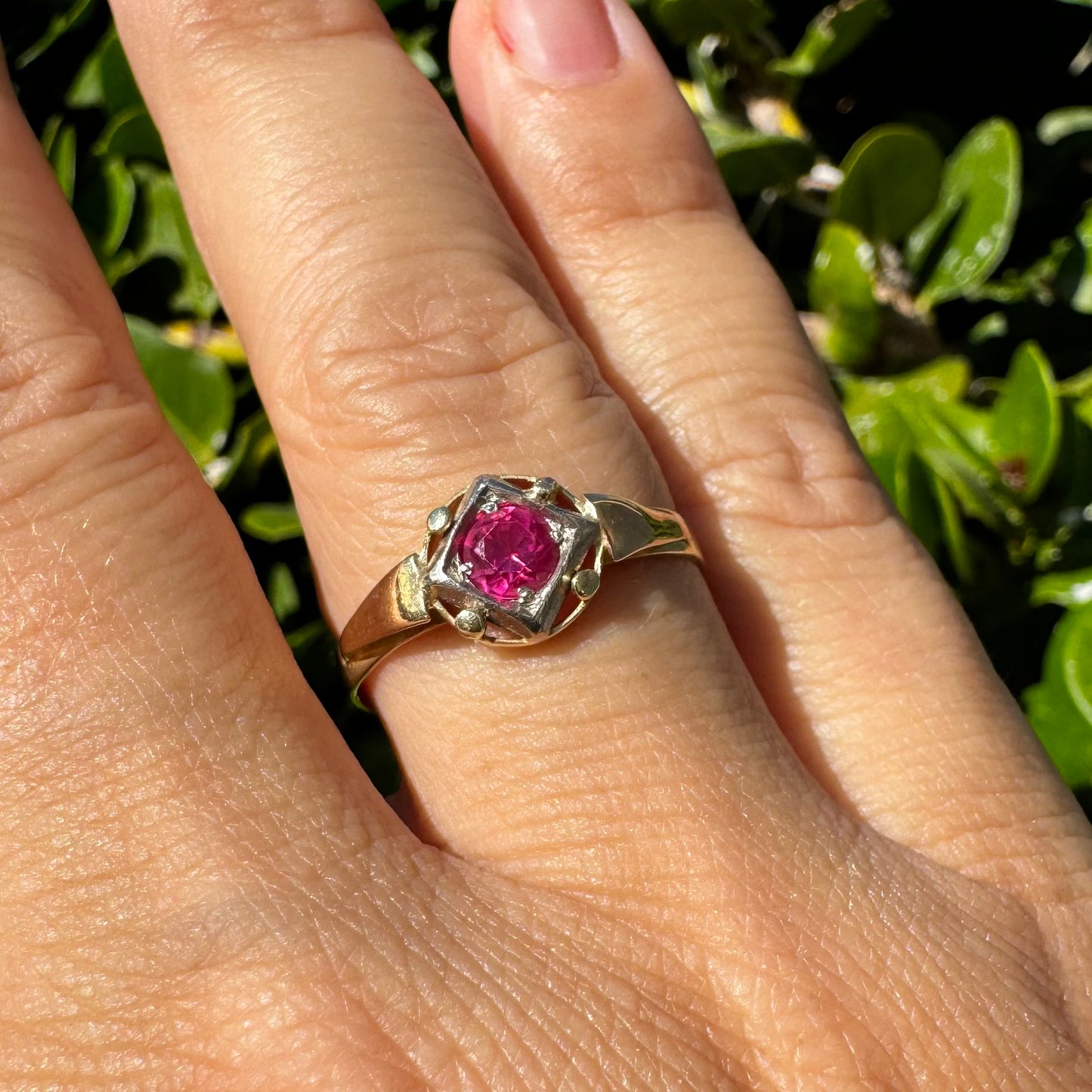 14K gold ring set with a vivid round-cut Ruby set in a geometric white gold frame.