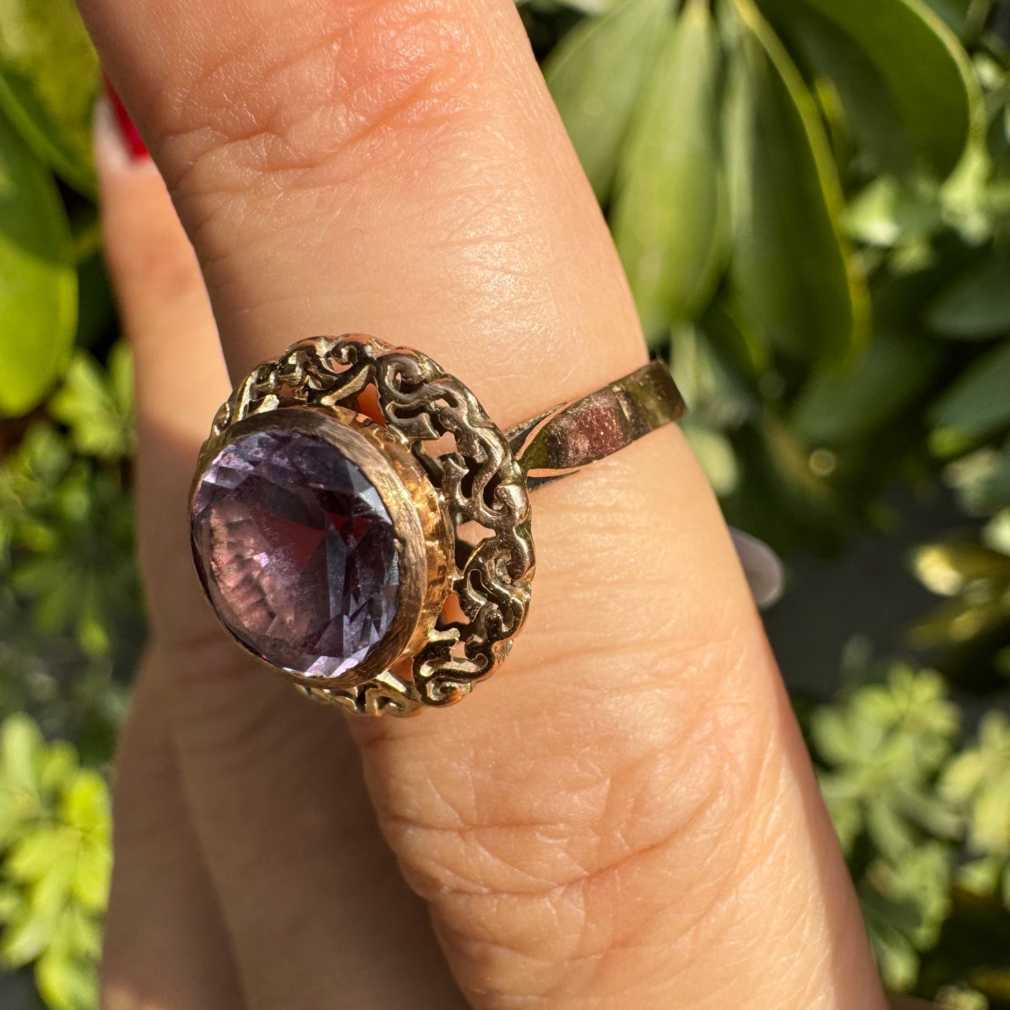 14K gold ring set with a large round-cut Tanzanite framed by an ornate filigree bezel