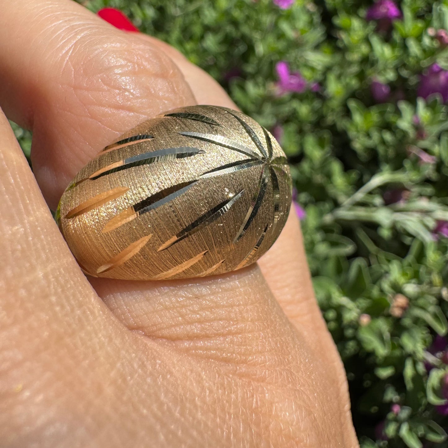 14K gold dome ring crafted in textured gold, featuring intricate engraved starburst detailing