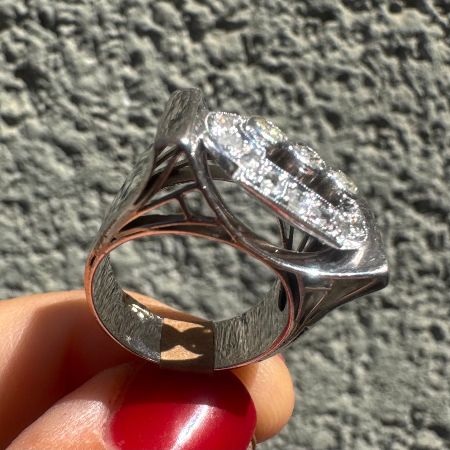 18K gold ring featuring three round 3 Diamonds in the center, framed by a rectangular halo of smaller Diamonds.