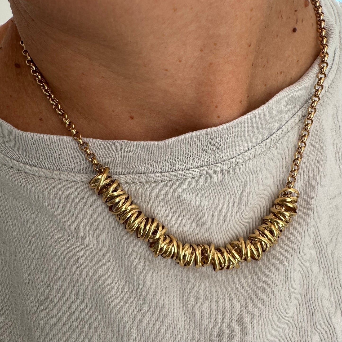 14K gold necklace featuring a series of intertwined gold rings creating a bold and sculptural design.