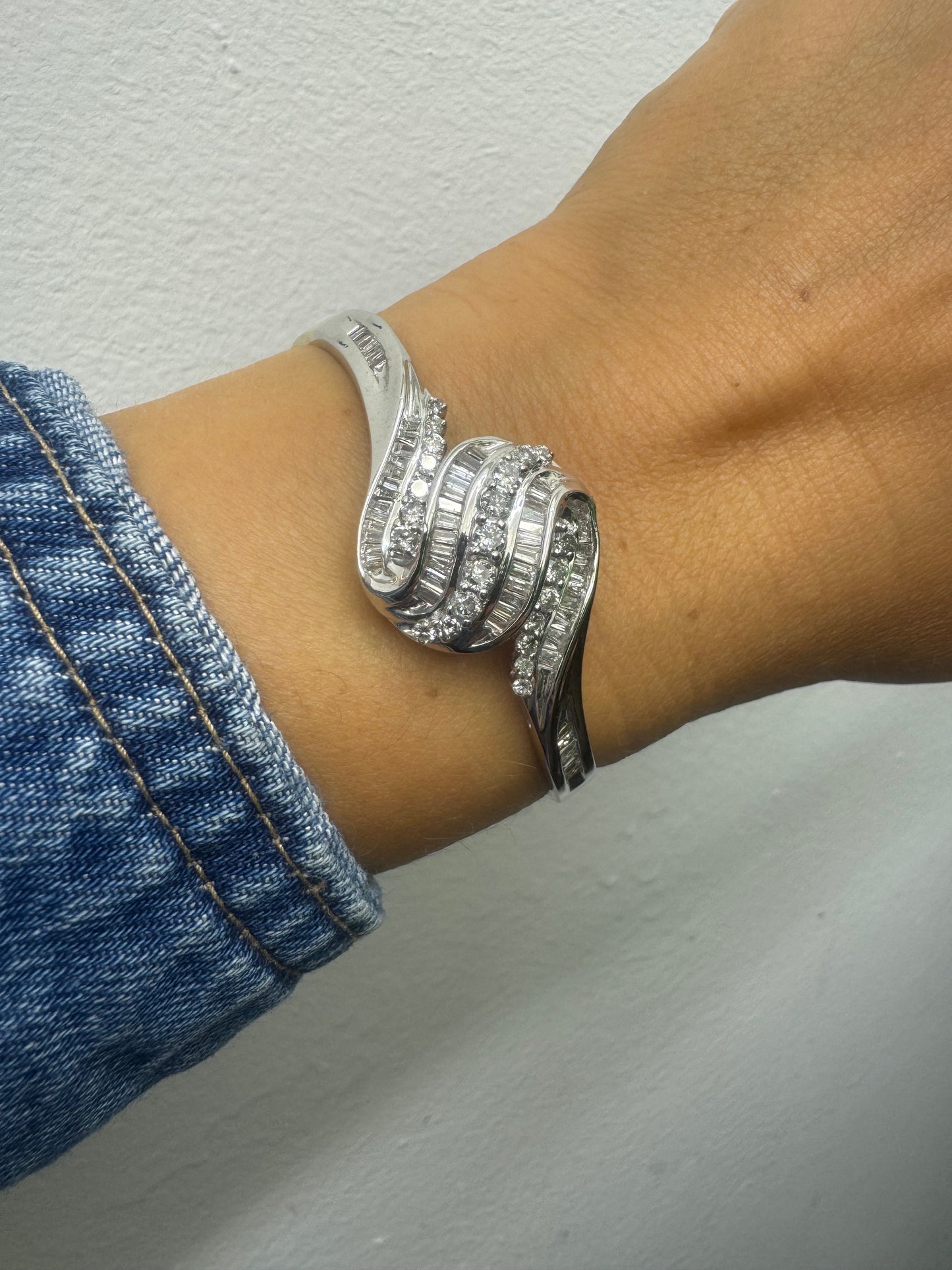 צמיד מרהיב מזהב לבן 14 קראט, בעיצוב גלים דינמי המשובץ בשיבוץ מרוכב של יהלומים עגולים ובחיתוך באגט.