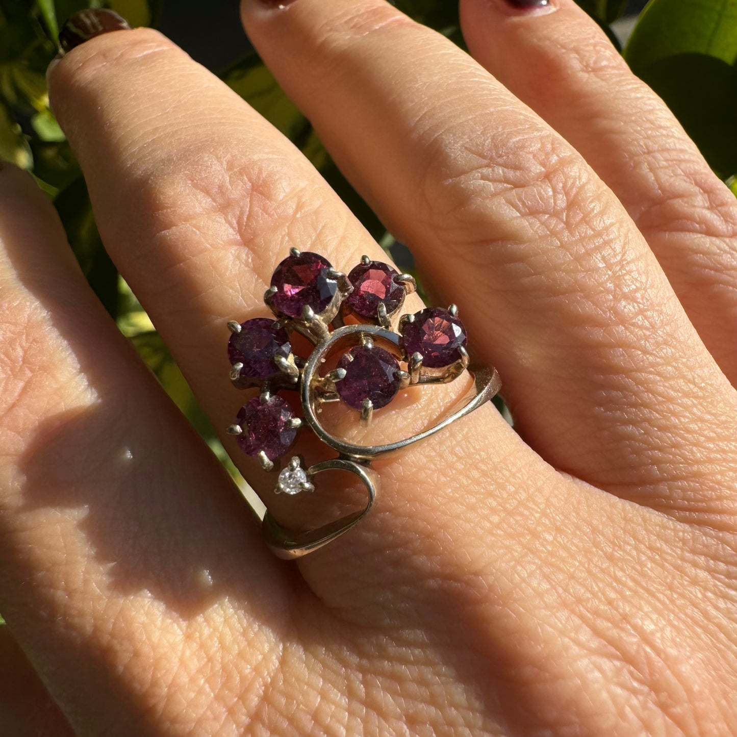 14K gold ring with an open, flowing design, set with multiple pink Tourmaline stones and accented by a Diamond