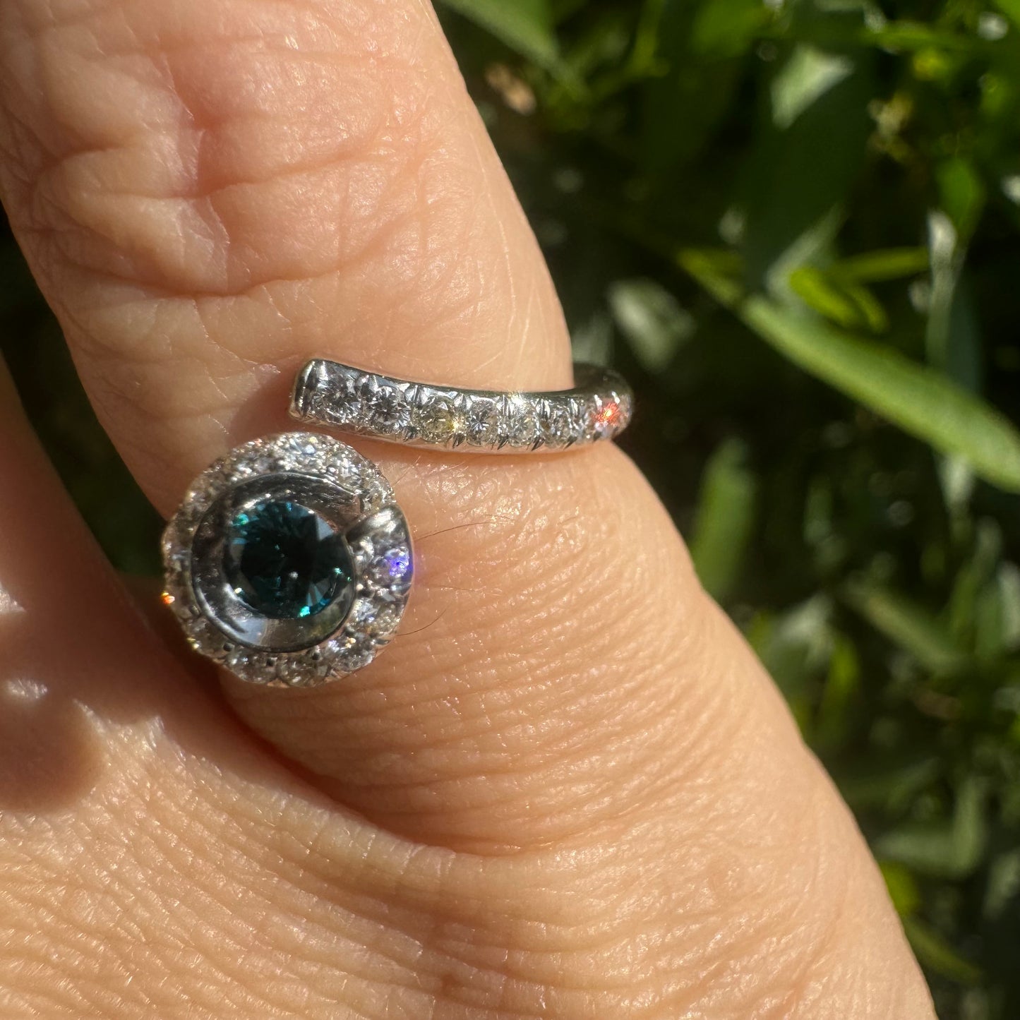 18K gold ring set with a vivid blue Diamond at its heart, embraced by a shimmering halo of white diamonds and a bold open design