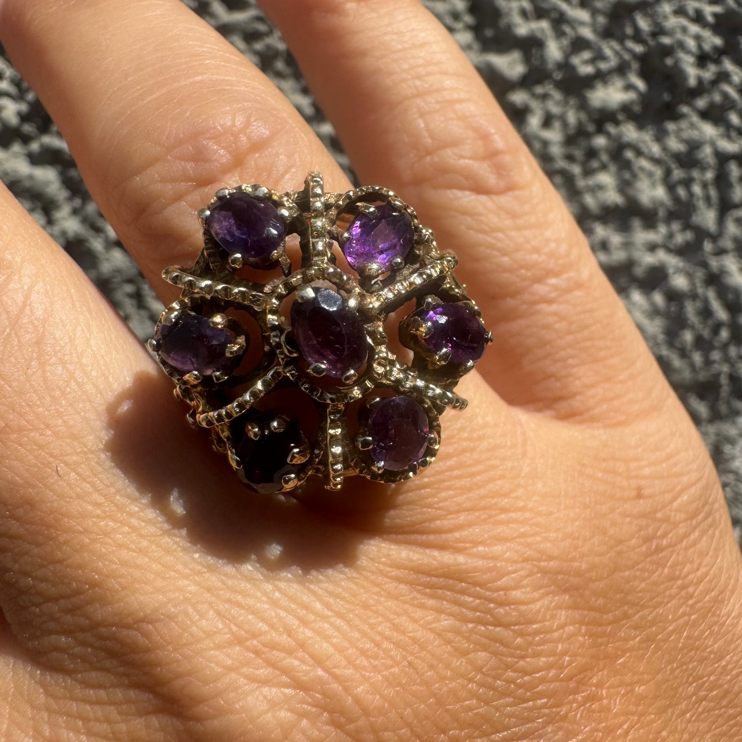 14K gold ring set with deep purple amethysts in an ornate floral design.
