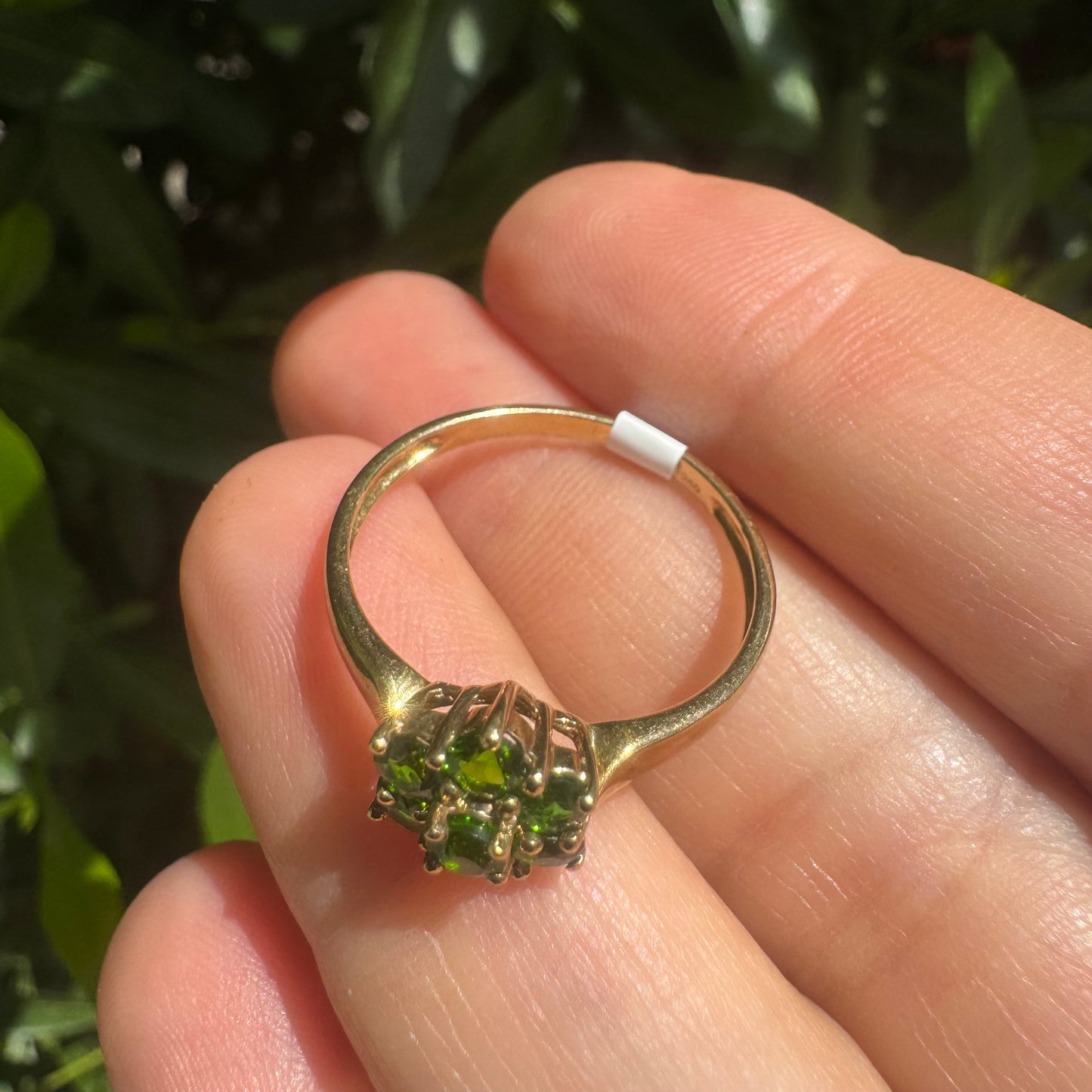10K gold ring set with vivid green gemstones in a delicate floral cluster