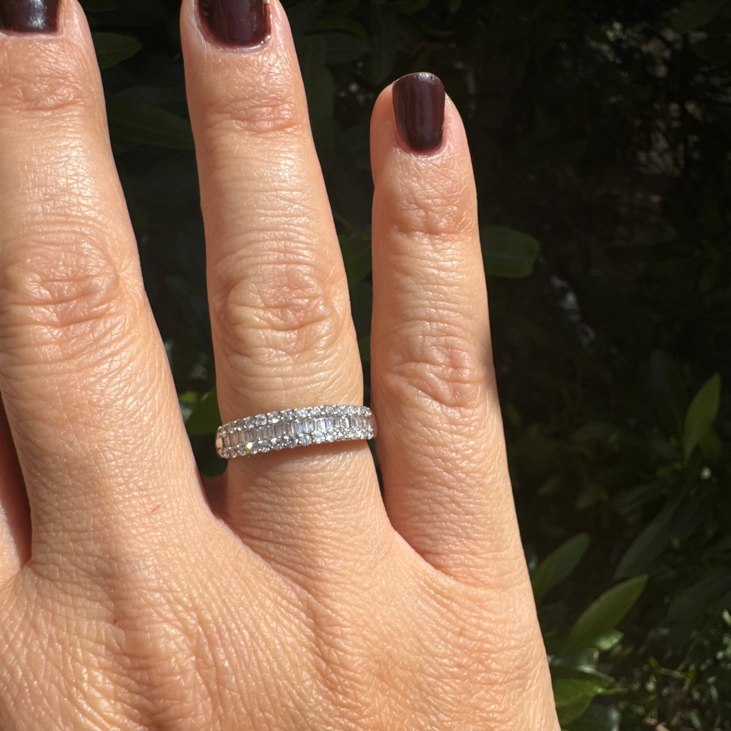 14K gold ring set with a row of baguette-cut diamonds framed by two rows of brilliant round diamonds