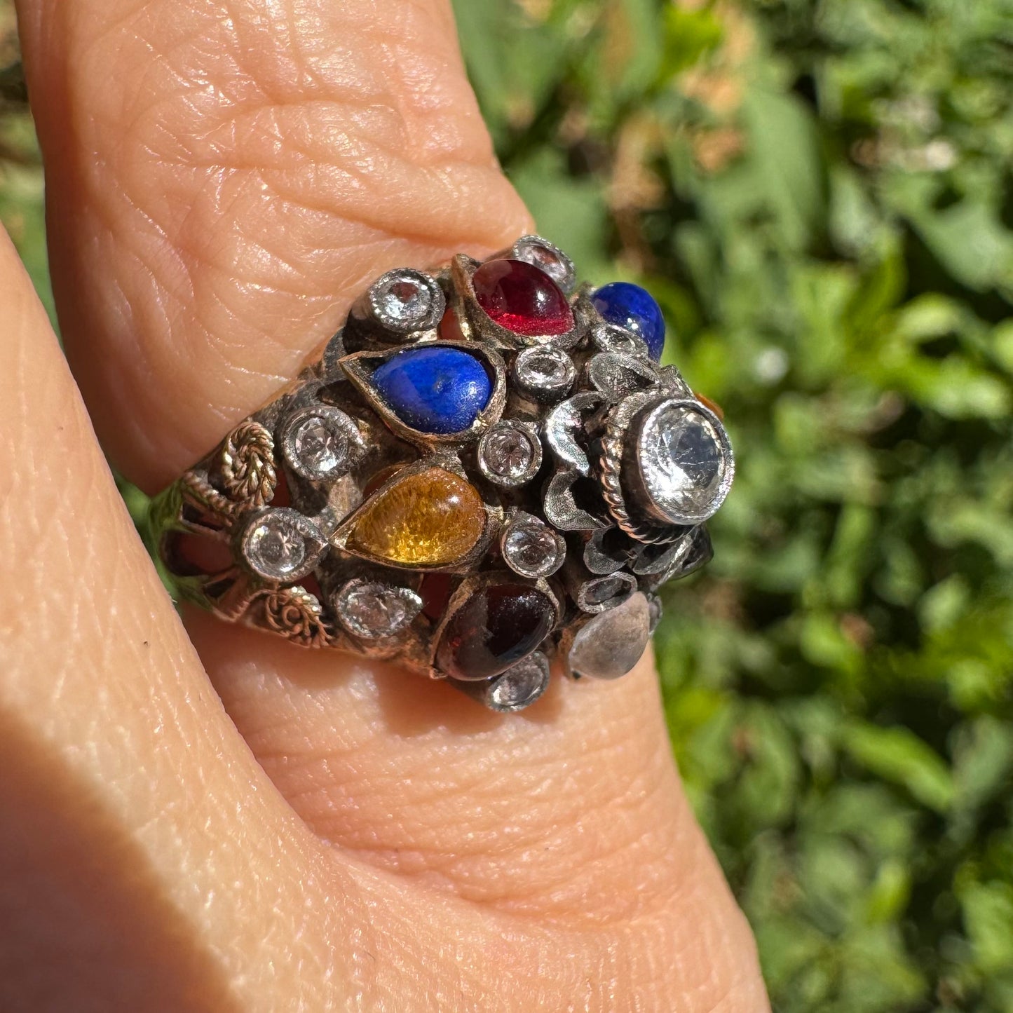 14K gold ring set with a central transparent gemstone surrounded by a vibrant mosaic of colorful gemstones -set in an ornate, handcrafted design