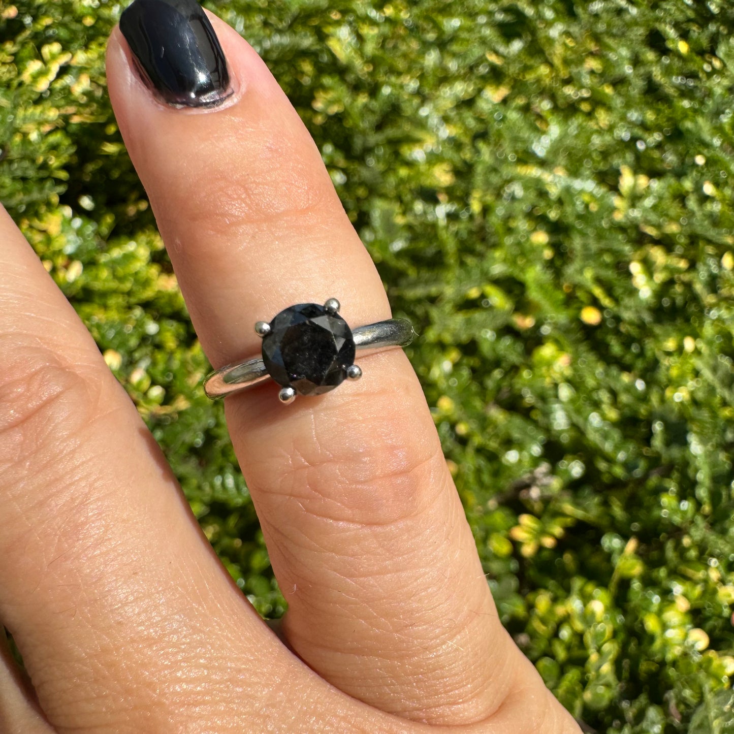 טבעת סוליטר זהב לבן 10 קראט אלגנטית ובעלת נוכחות, משובצת ביהלום שחור בחיתוך עגול במסגרת קלאסית בעלת ארבע שיניים מזהב לבן.