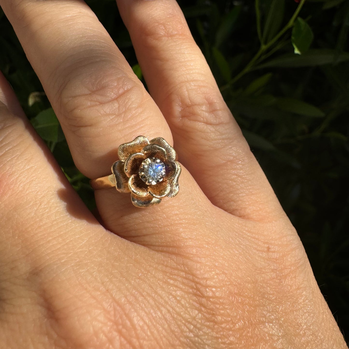 14K Gold floral ring set with delicately textured petals and a sparkling Diamond at the center