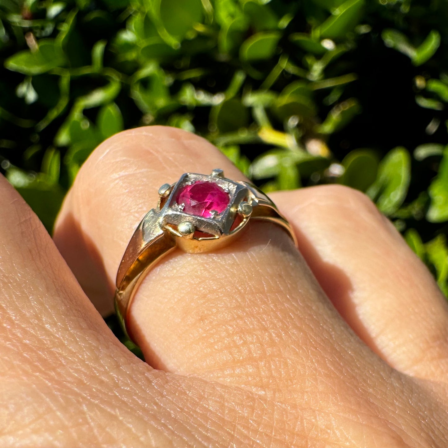 14K gold ring set with a vivid round-cut Ruby set in a geometric white gold frame.