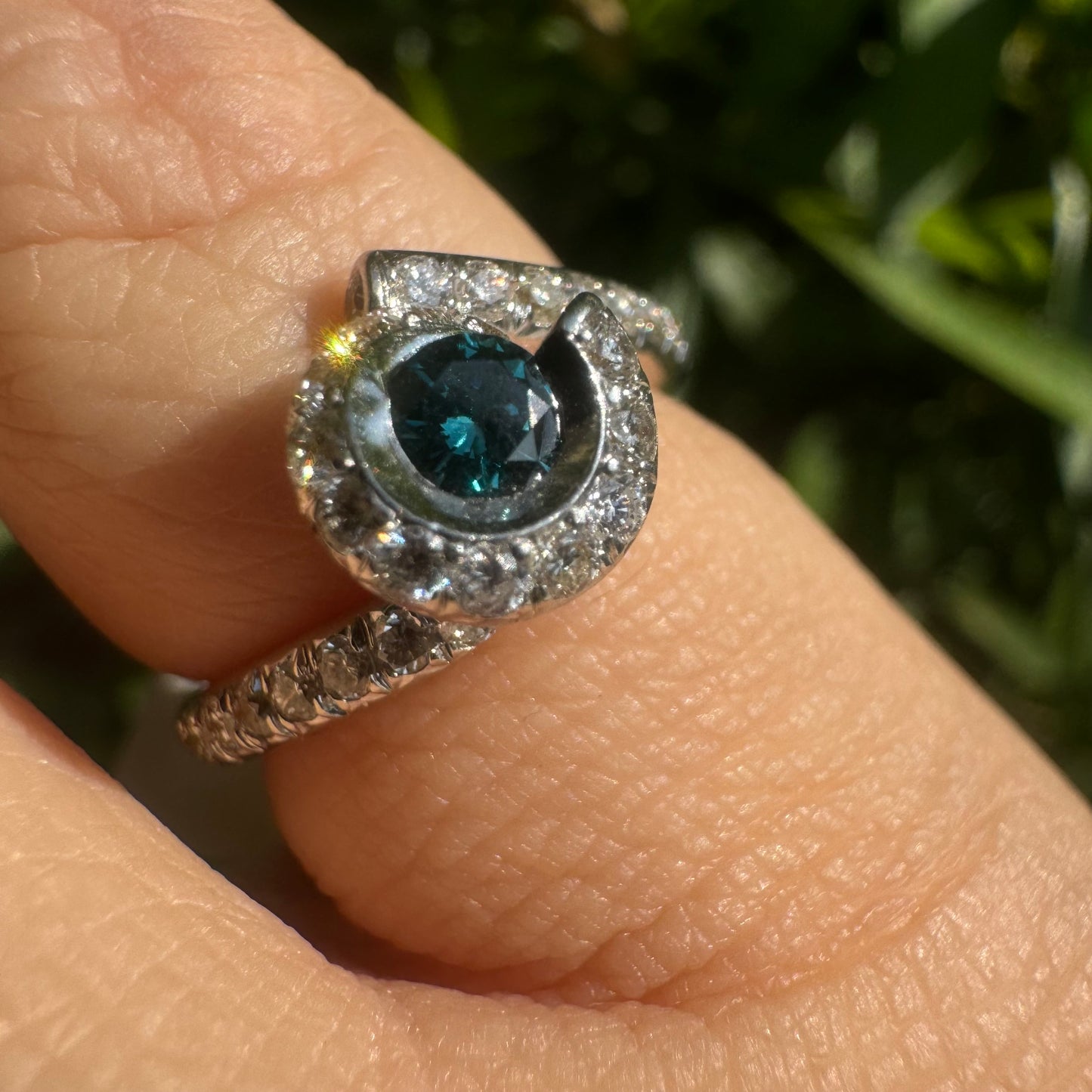 18K gold ring set with a vivid blue Diamond at its heart, embraced by a shimmering halo of white diamonds and a bold open design