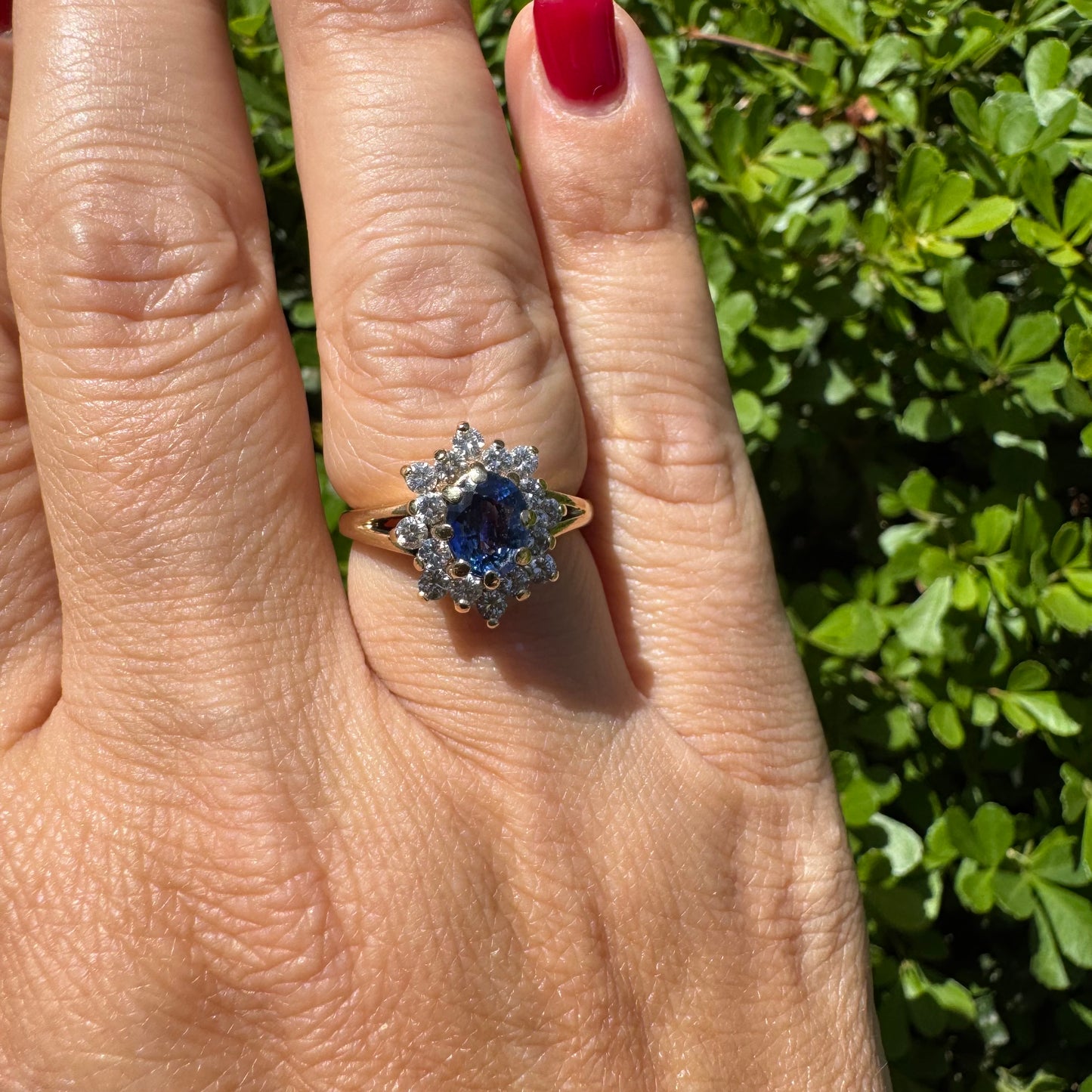 14K gold ring set with a vivid blue Sapphire surrounded by a sparkling halo of brilliant-cut Diamonds