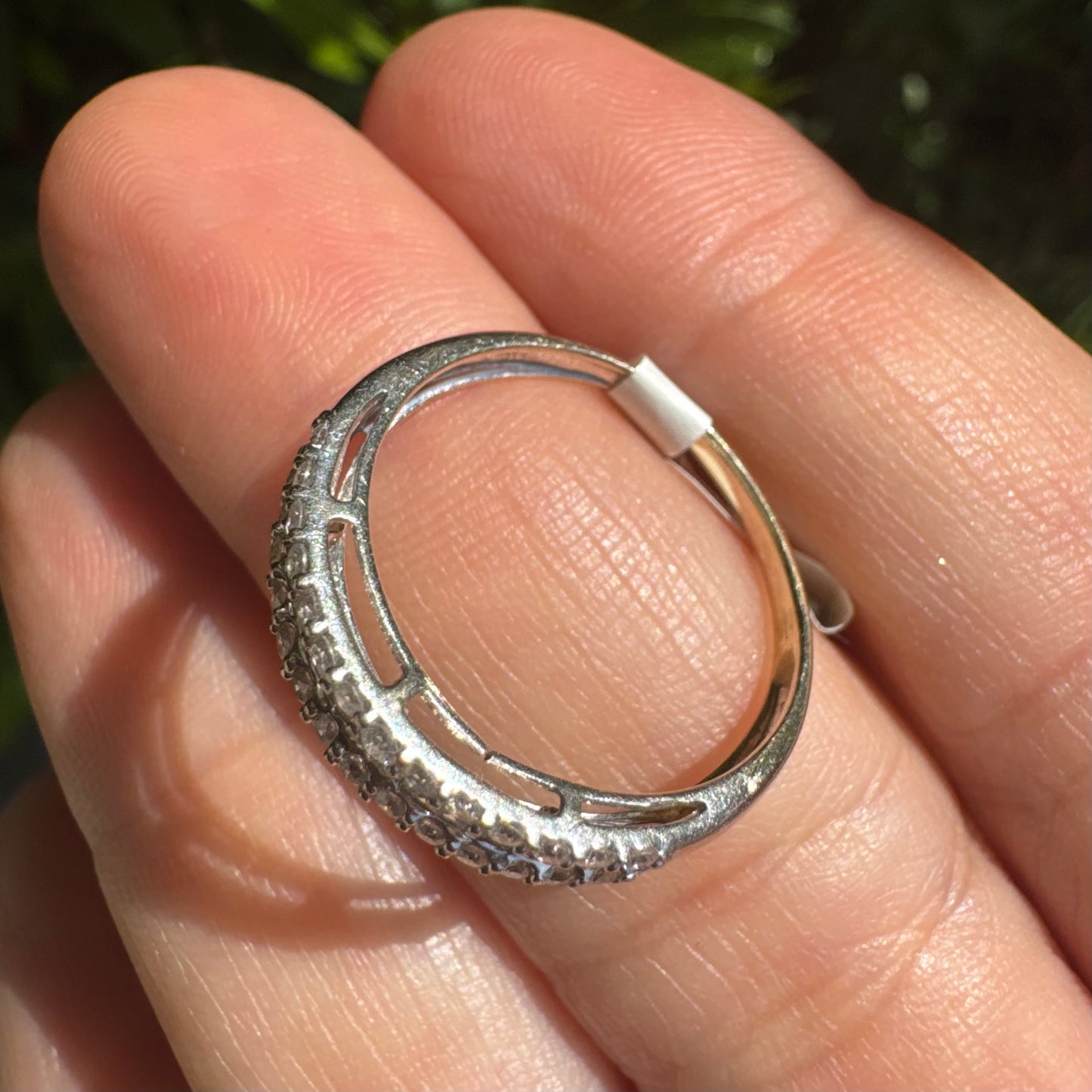 14K gold ring set with a row of baguette-cut diamonds framed by two rows of brilliant round diamonds