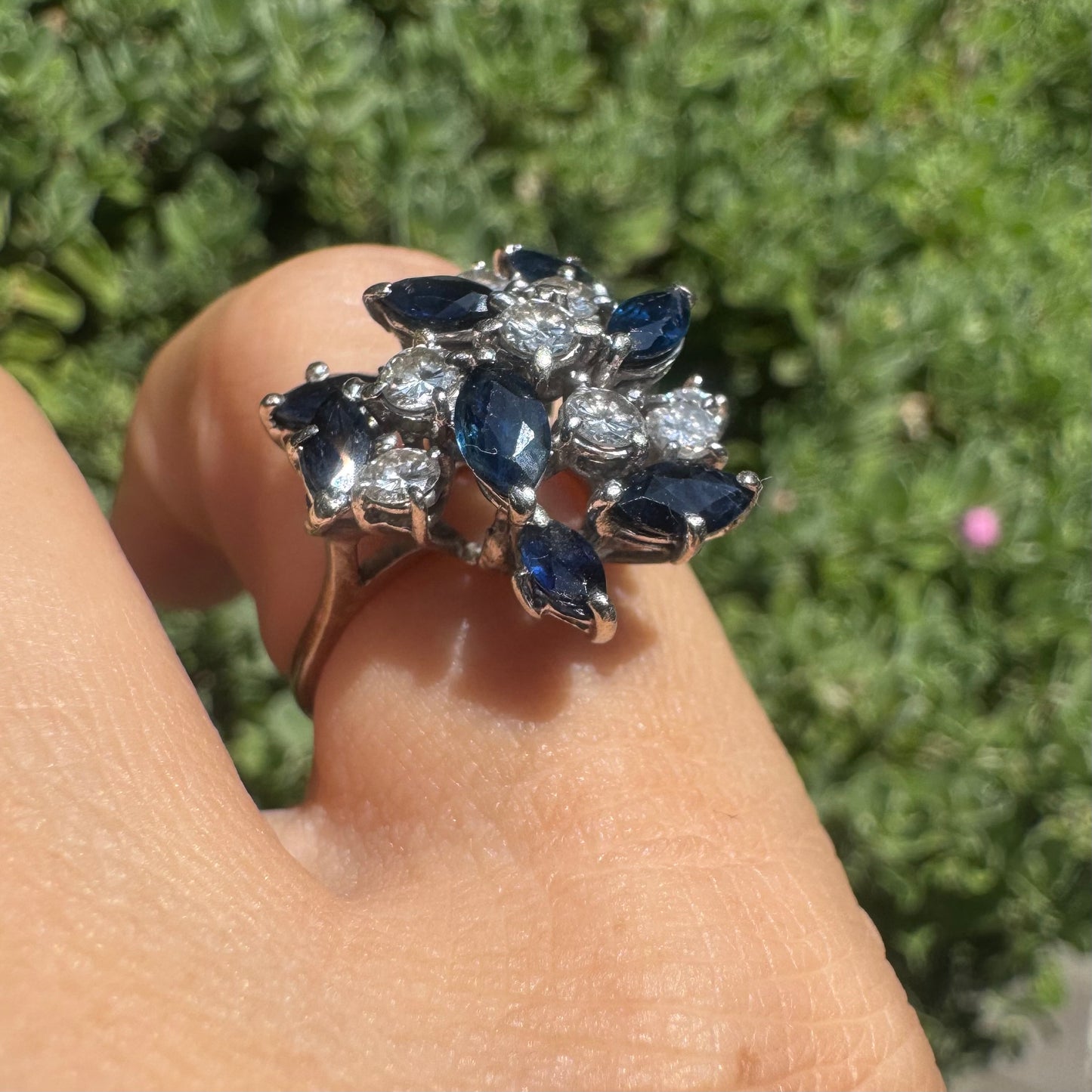 18K gold cluster ring featuring marquise-cut blue sapphires and round brilliant Diamonds arranged in a floral design.