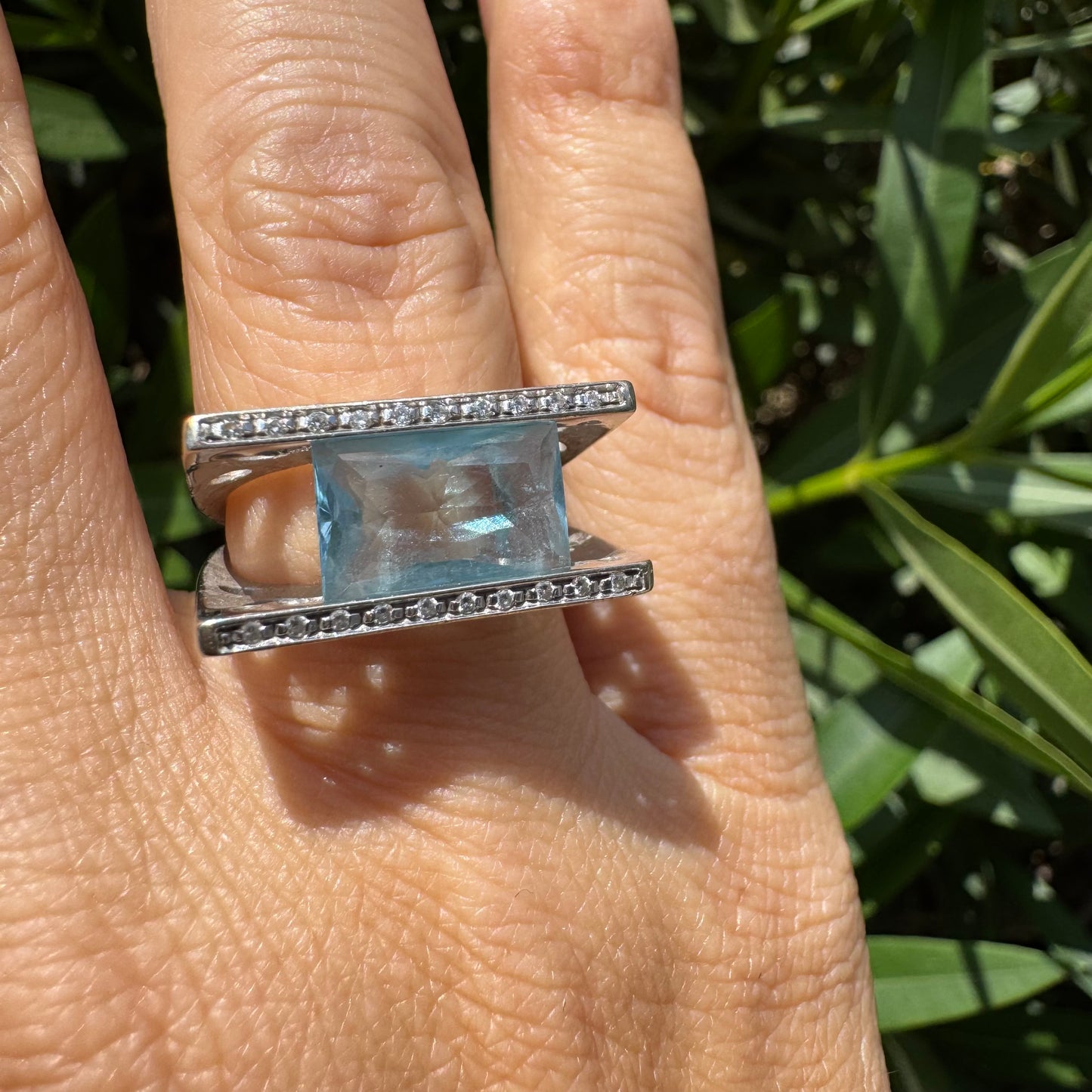 18K gold ring set with a stunning Aquamarine centerpiece held between two sleek gold bars set with delicate Diamonds.