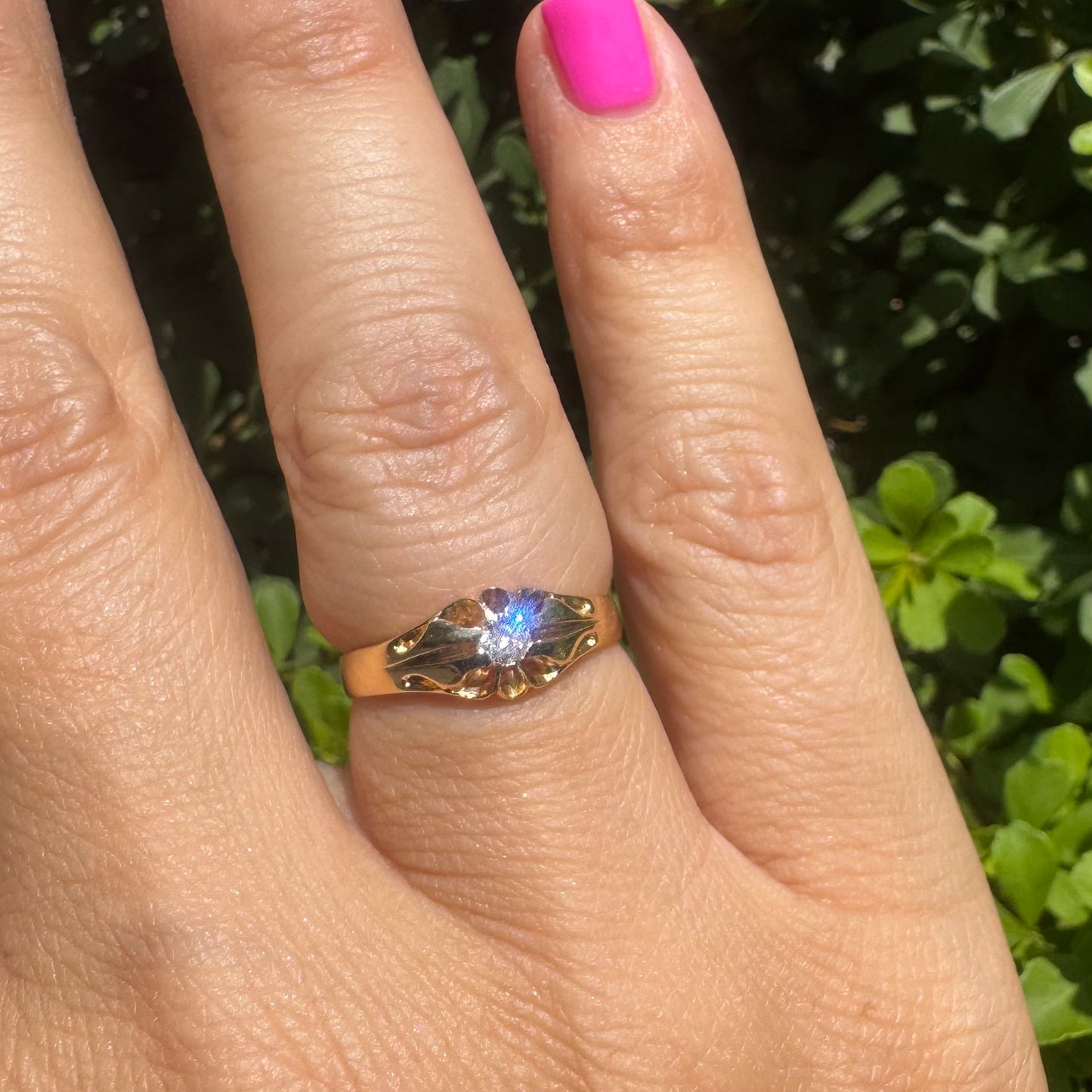 18K gold ring set with a small sparkling diamond at the center.