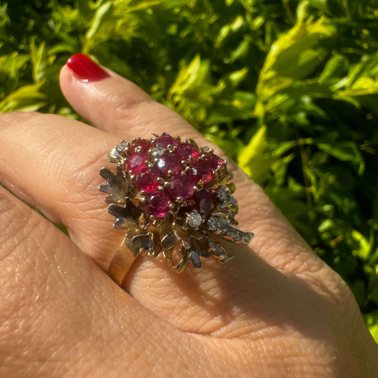 14K gold ring set with a vibrant cluster of deep red rubies and sparkling diamonds.