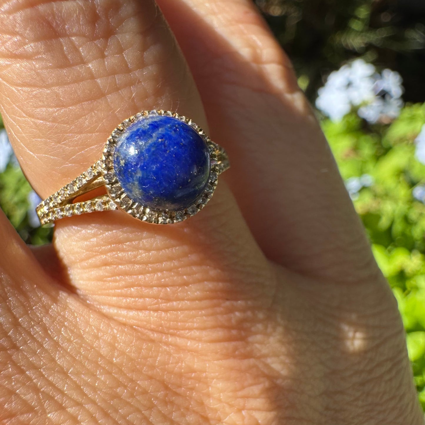 14K gold ring set with a round Lapis Lazuli gemstone, surrounded by a delicate halo of sparkling Diamonds.