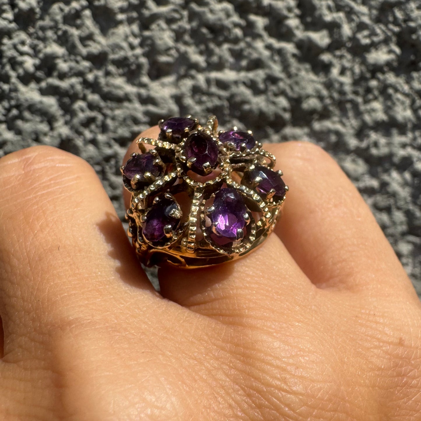 14K gold ring set with deep purple amethysts in an ornate floral design.
