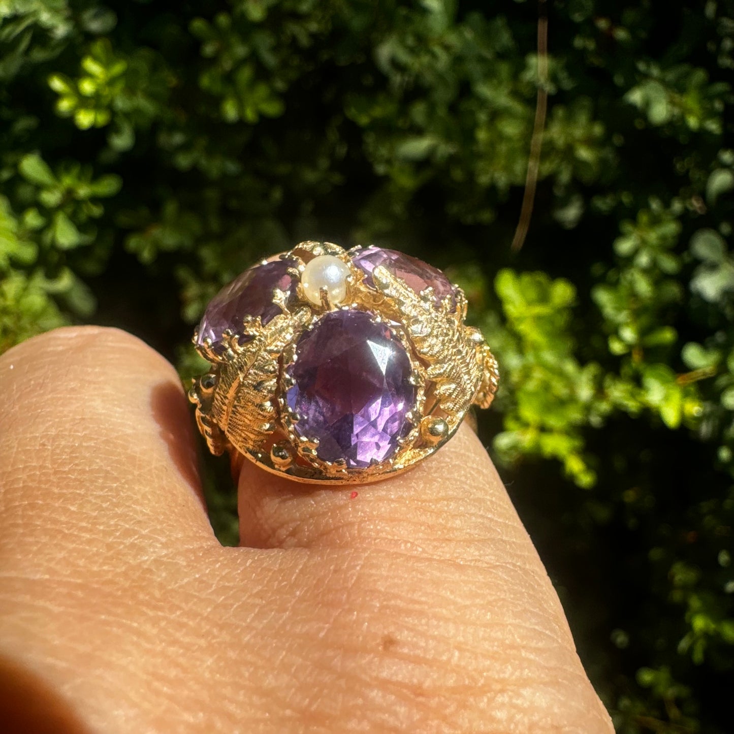 14K gold ring set with four glowing Amethyst stones encircling a delicate central Pearl.