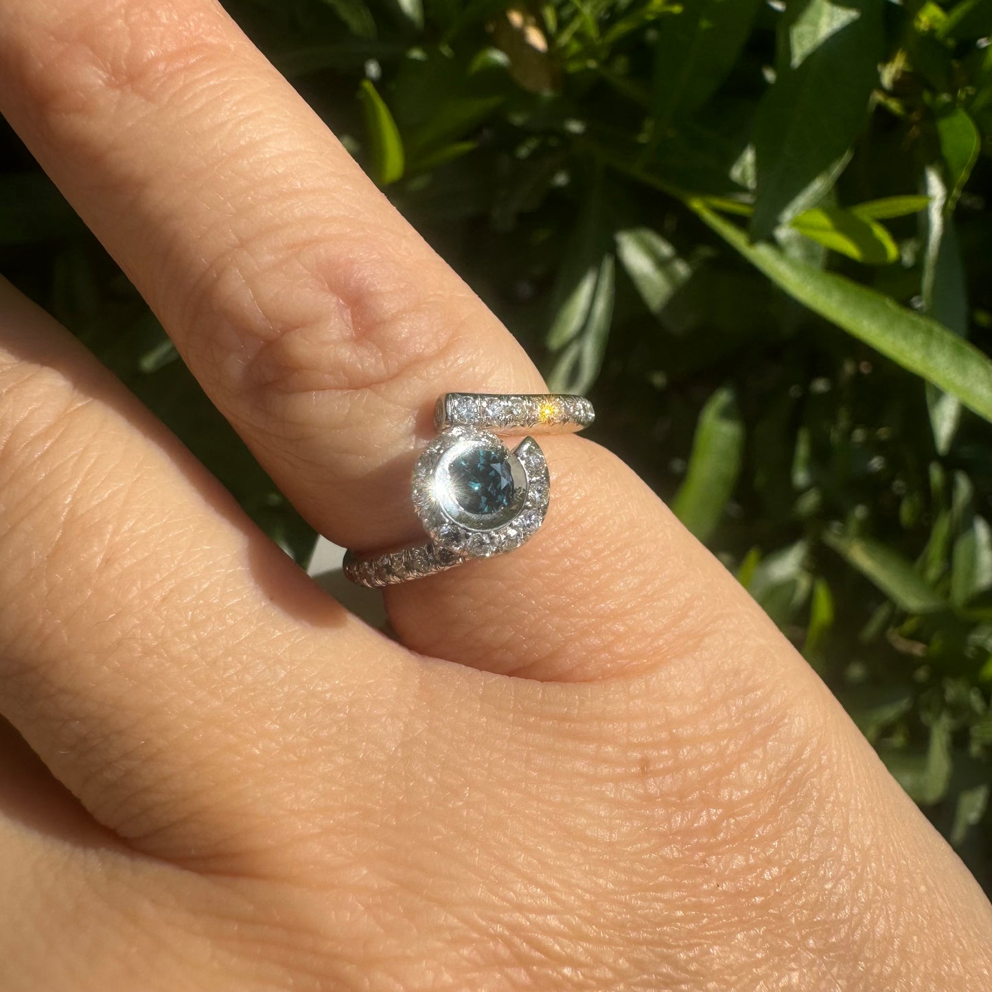 18K gold ring set with a vivid blue Diamond at its heart, embraced by a shimmering halo of white diamonds and a bold open design