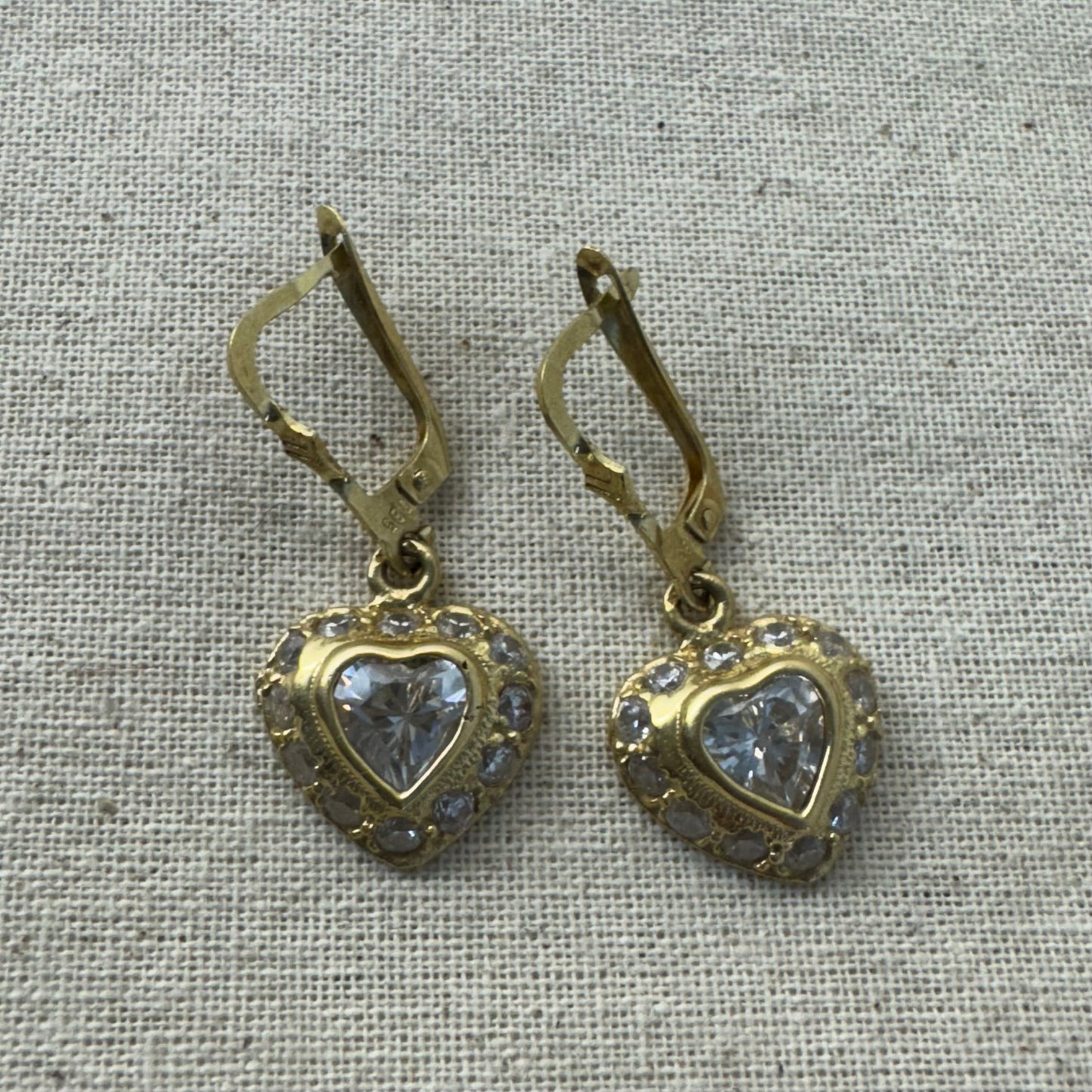 14K gold drop earrings set with a heart-cut central stone & surrounded by a halo of delicate gems.