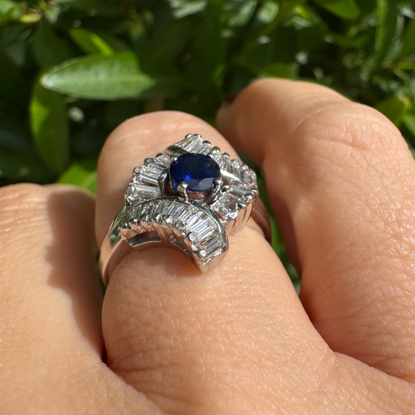 14K gold ring set with a round deep blue sapphire at the center, surrounded by baguette cut Diamonds