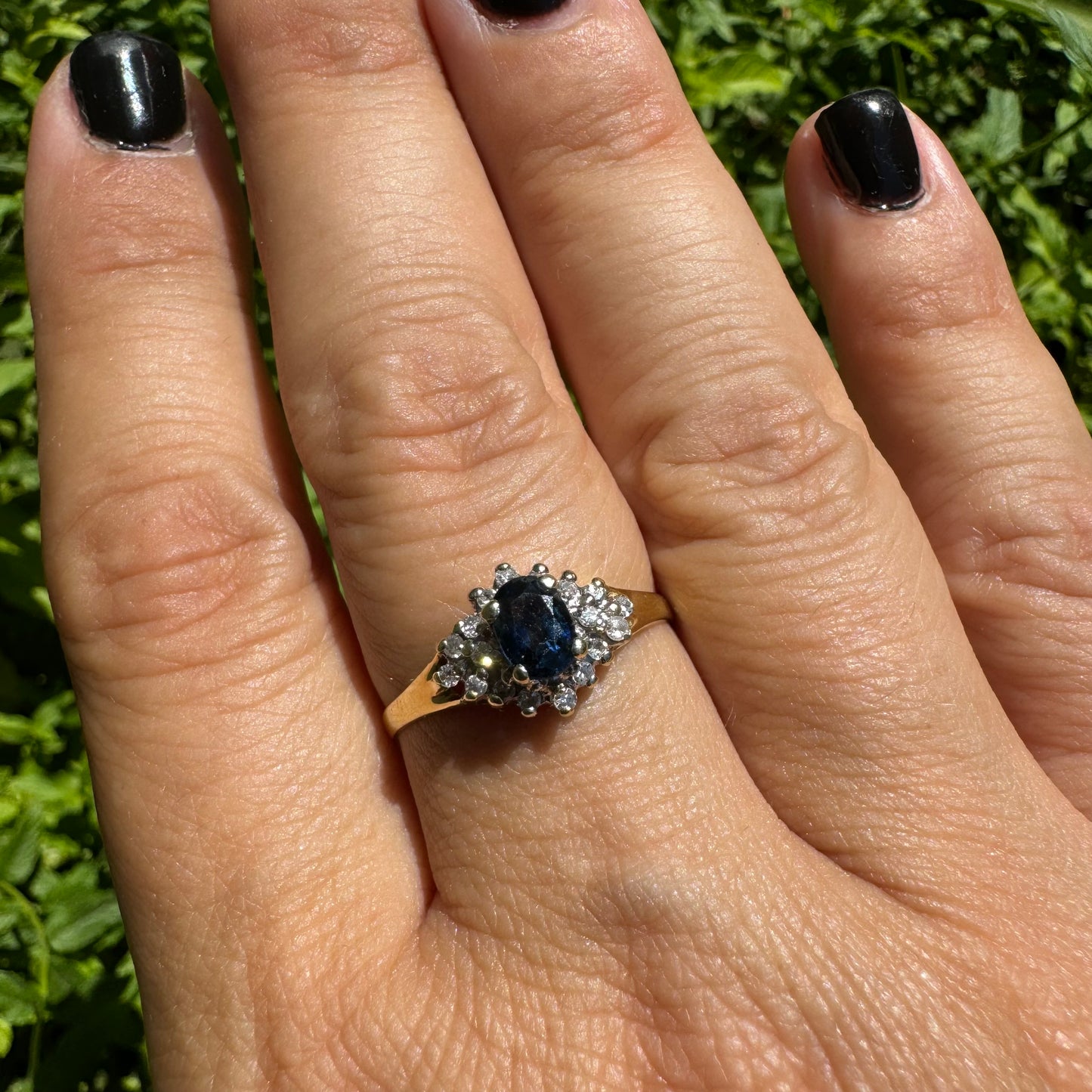14K gold ring set with an oval blue Sapphire surrounded by sparkling Diamonds