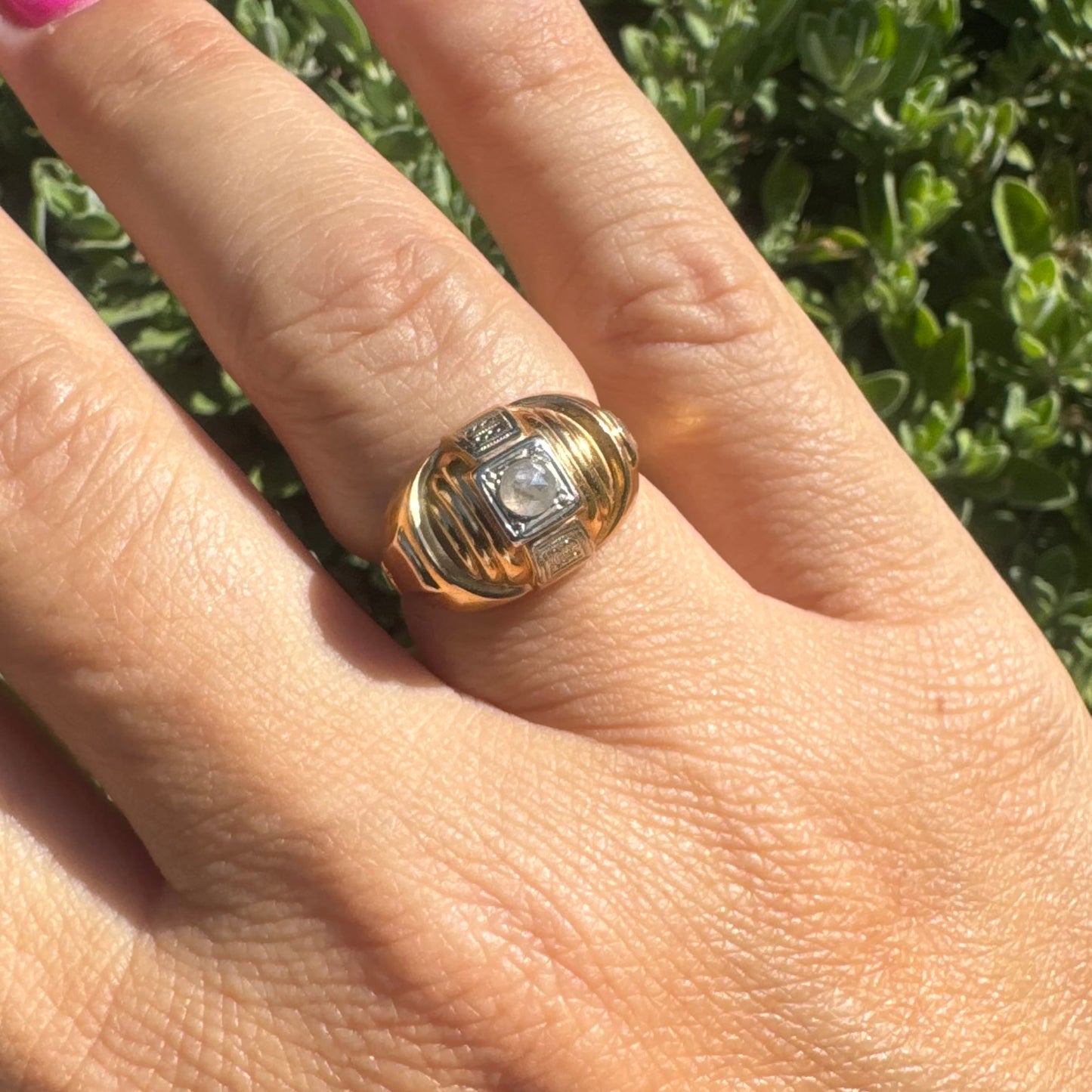 18K gold ring featuring a central round Diamond set in a square bezel with decorative details.