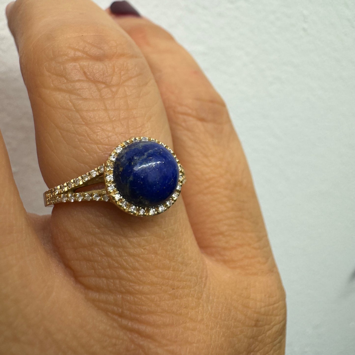 14K gold ring set with a round Lapis Lazuli gemstone, surrounded by a delicate halo of sparkling Diamonds.