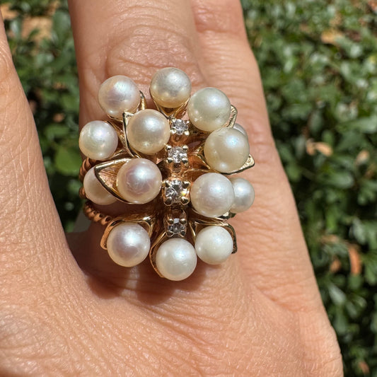 טבעת זהב צהוב 14 קראט משובצת בשפע של פנינים עגולות ולבנות, עם שורת יהלומים קטנים במרכז – יוצרת מראה פרחוני וזוהר שמושך את העין.