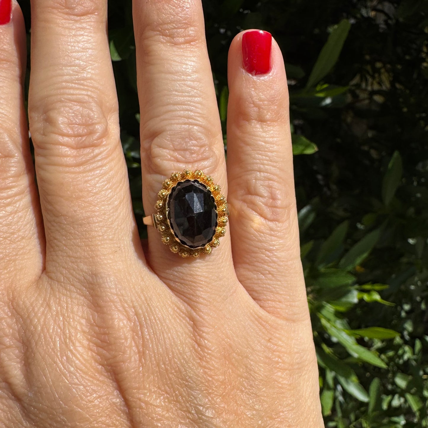 14K gold ring set with a large Garnet surrounded by delicate gold details