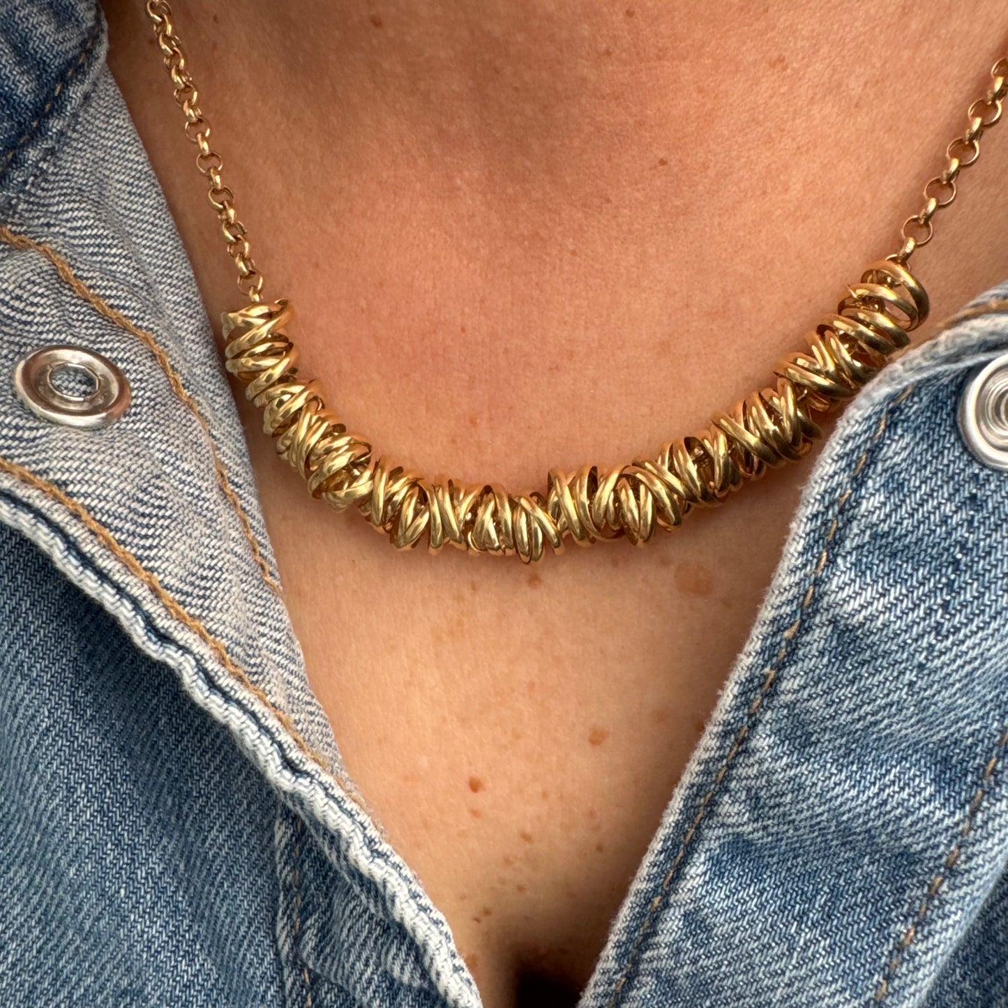 14K gold necklace featuring a series of intertwined gold rings creating a bold and sculptural design.