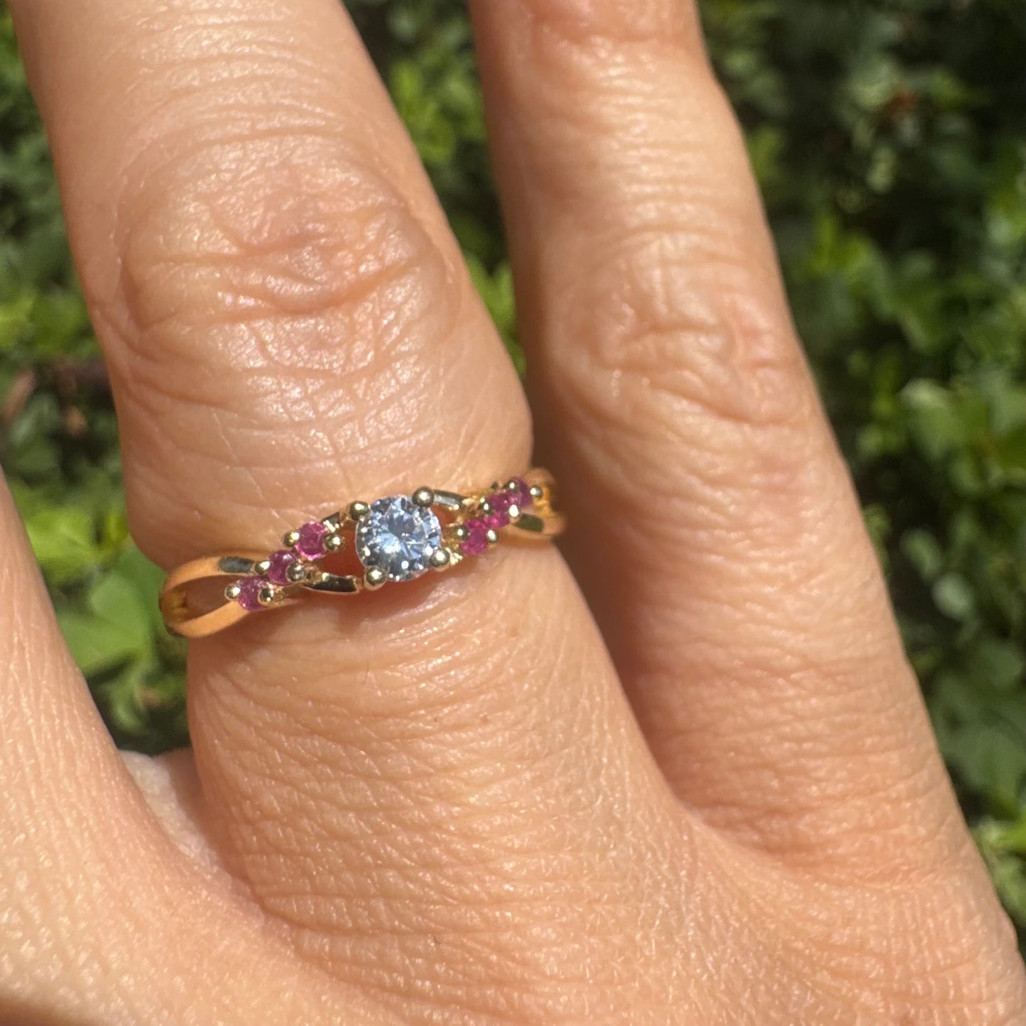 14K gold ring set with a central round Diamond, accented with Rubies along the band.