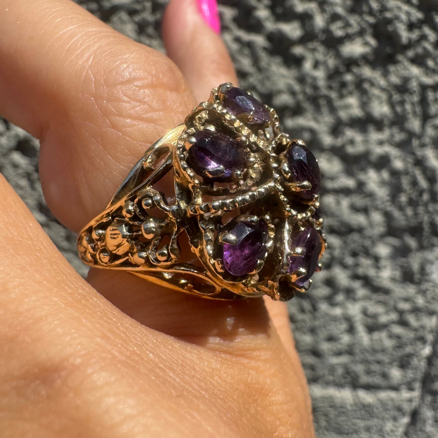 14K gold ring set with deep purple amethysts in an ornate floral design.