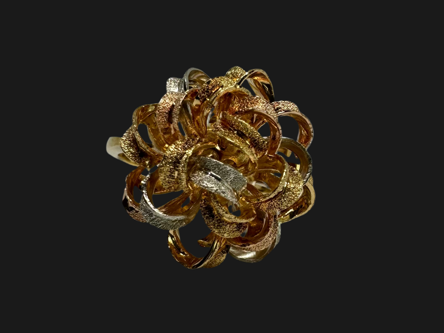18K gold ring set with intricately textured loops in yellow, white, and rose gold, forming a bold floral-inspired sculptural design.
