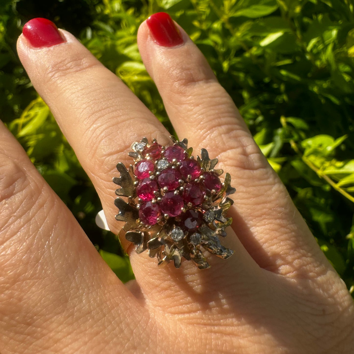 14K gold ring set with a vibrant cluster of deep red rubies and sparkling diamonds.