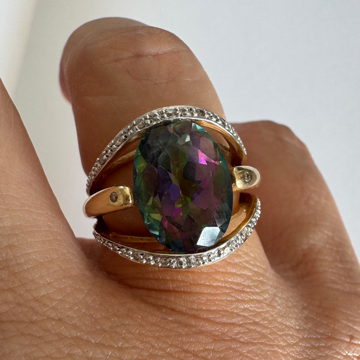 14K gold ring set with an oval Mystic Topaz