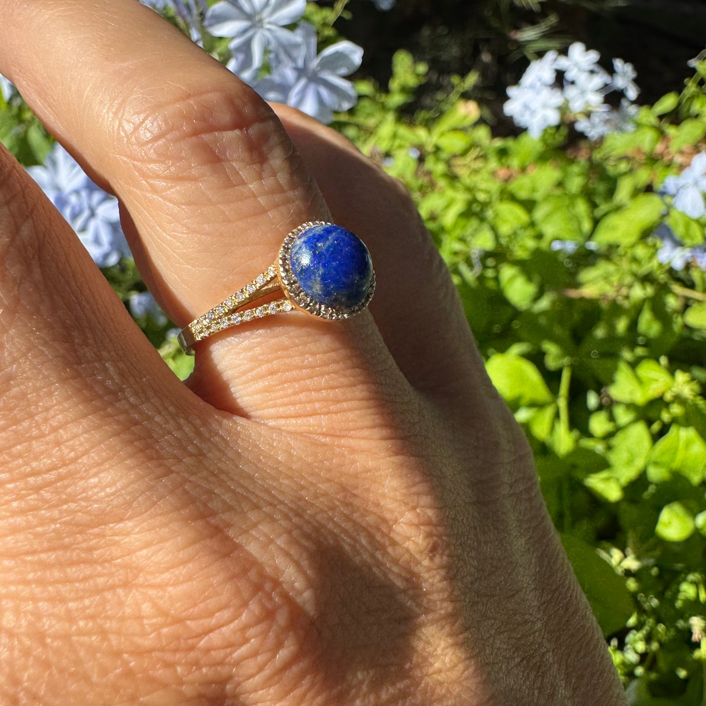 14K gold ring set with a round Lapis Lazuli gemstone, surrounded by a delicate halo of sparkling Diamonds.