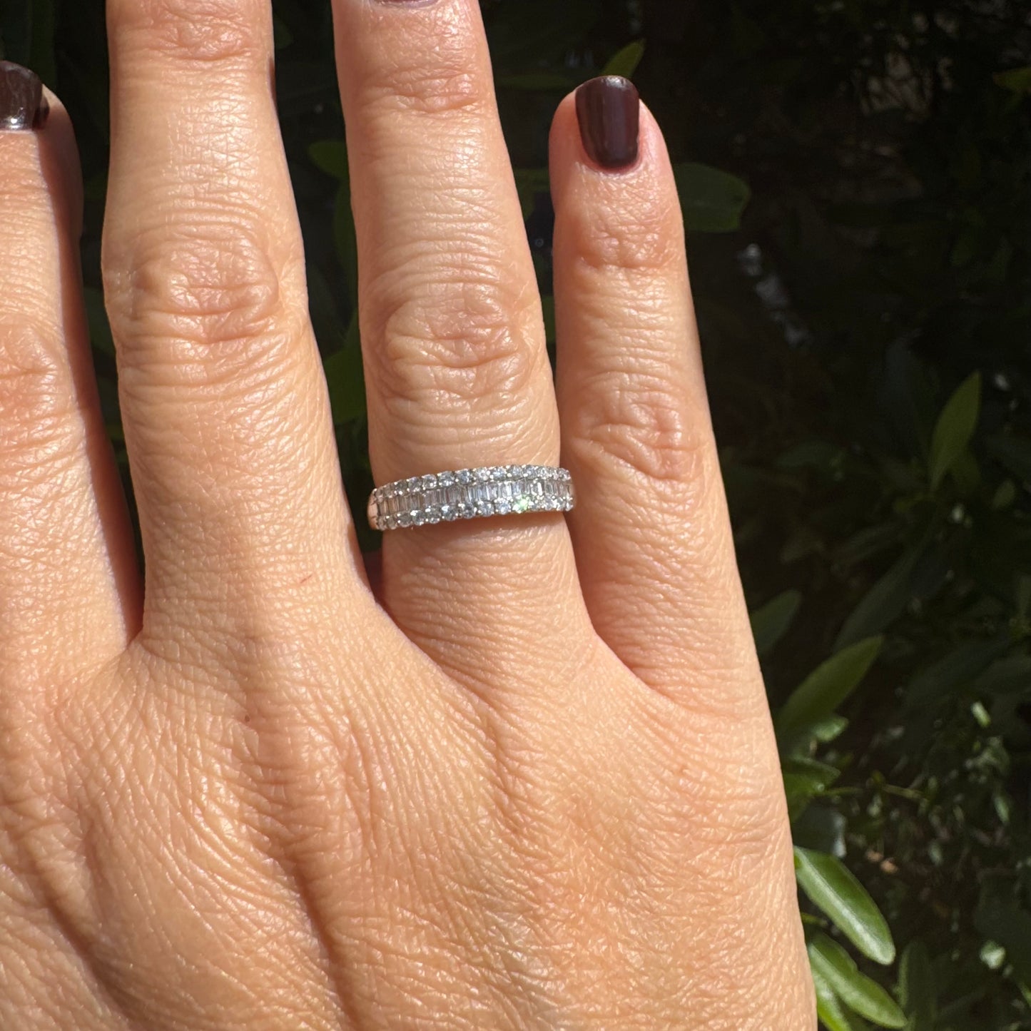 14K gold ring set with a row of baguette-cut diamonds framed by two rows of brilliant round diamonds