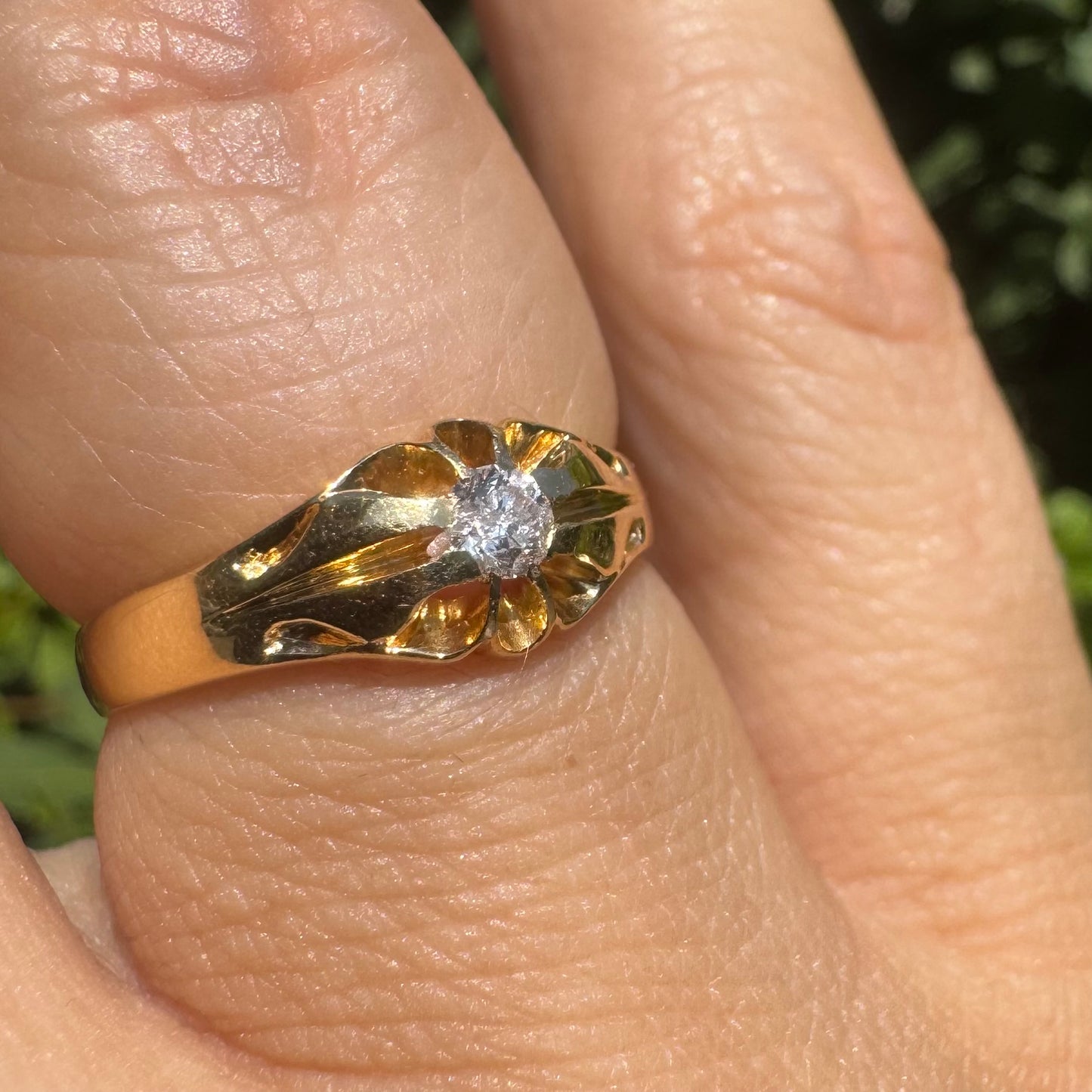 18K gold ring set with a small sparkling diamond at the center.