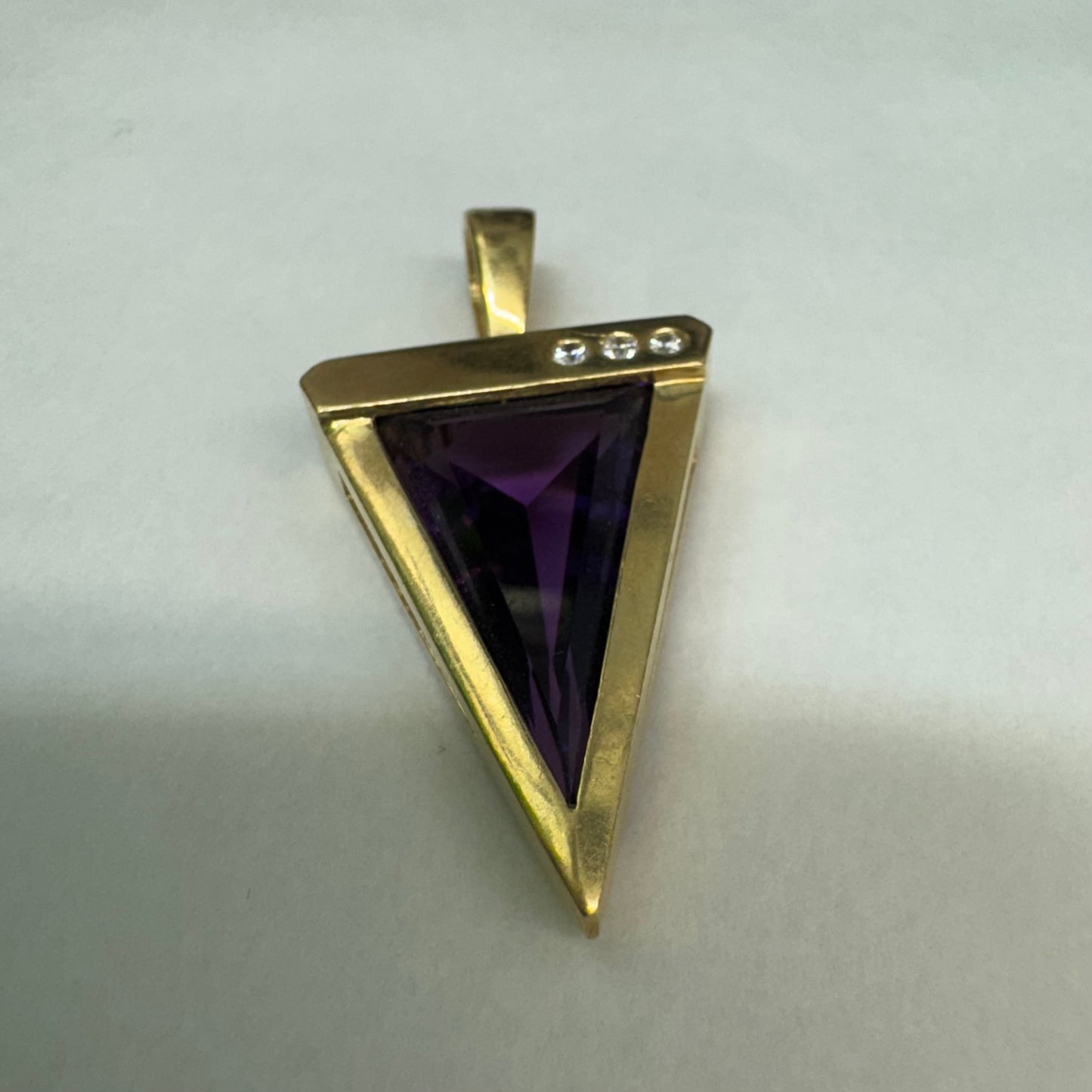 14K yellow gold pendant set with a triangular-cut amethyst and three accent diamonds