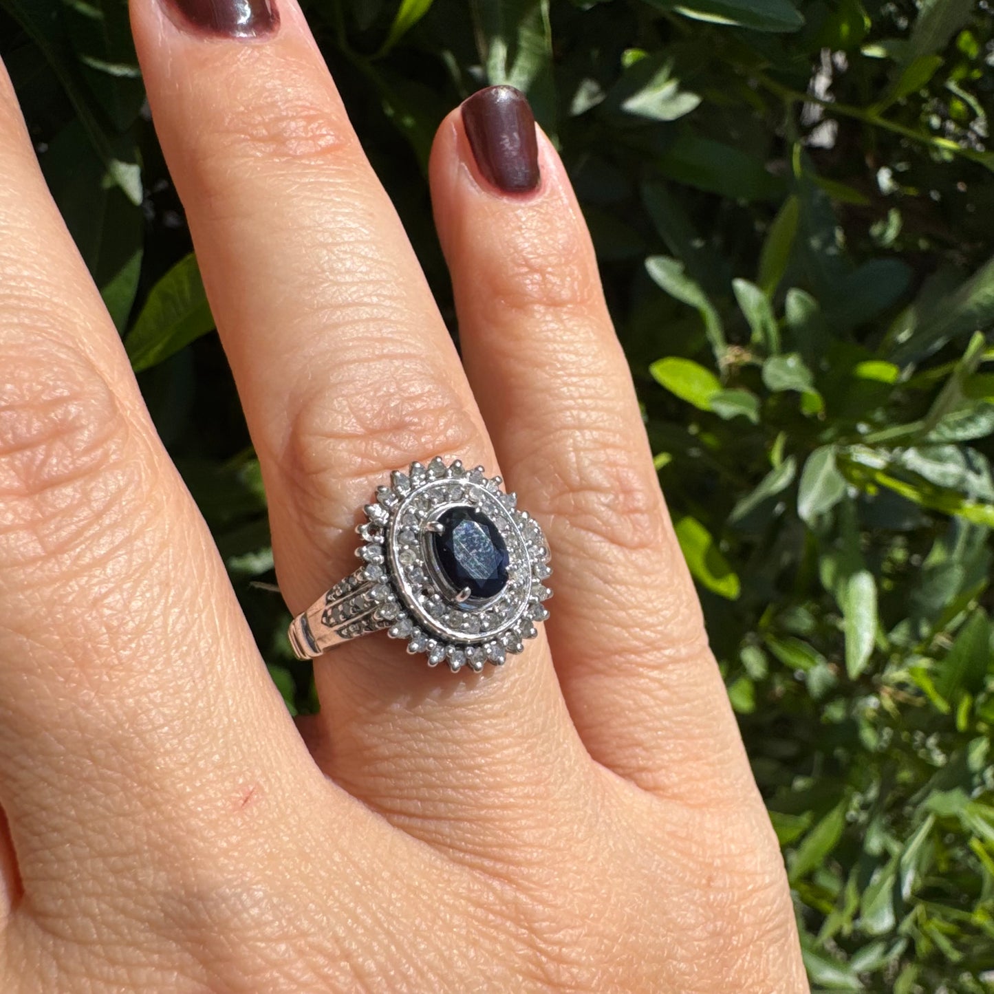 14K gold ring set with an oval-cut Sapphire, surrounded by a stunning double halo of brilliant round Diamonds