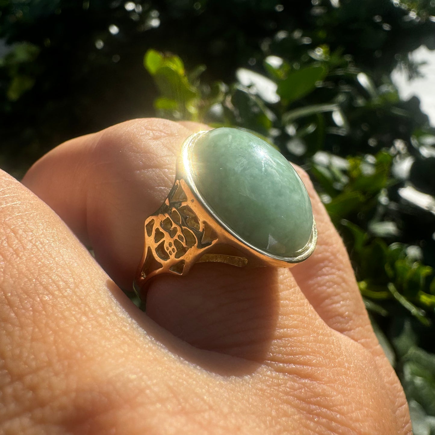 14K gold ring featuring a large oval light green Jade with a smooth polished finish, set in a classic bezel setting.