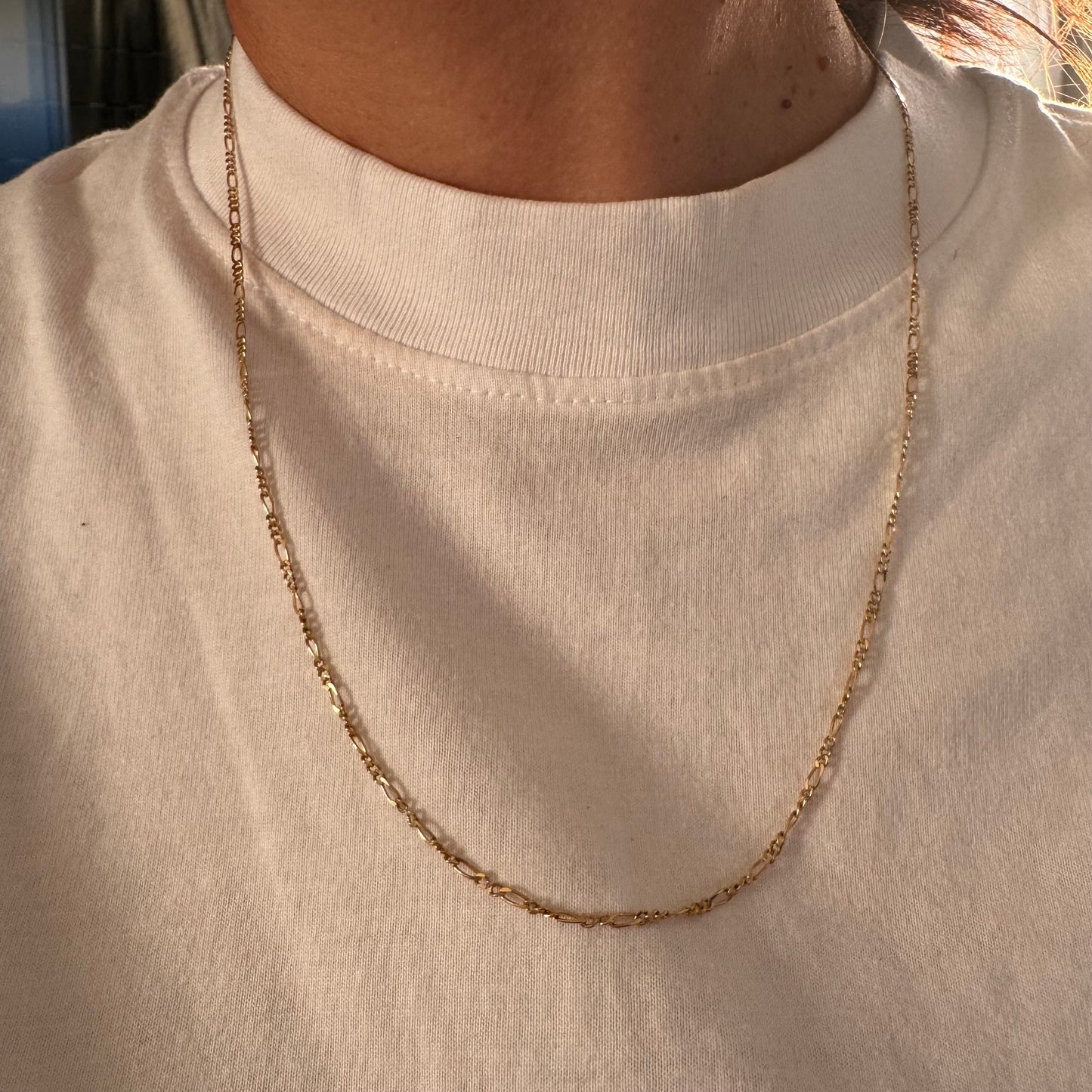 שרשרת זהב צהוב 14 קראט בעיצוב חוליות דקות ומוארכות עם טוויסט עדין שנותן לה מראה אלגנטי ונקי.