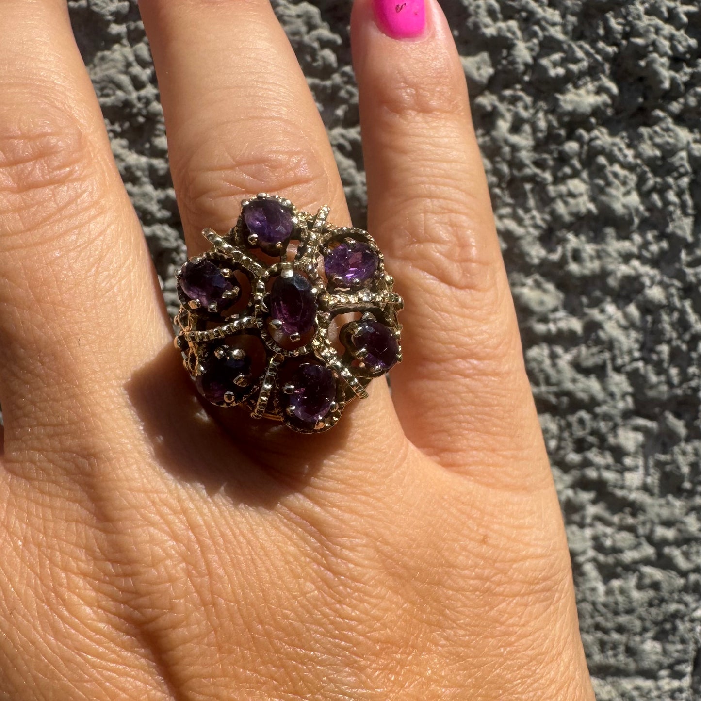 14K gold ring set with deep purple amethysts in an ornate floral design.