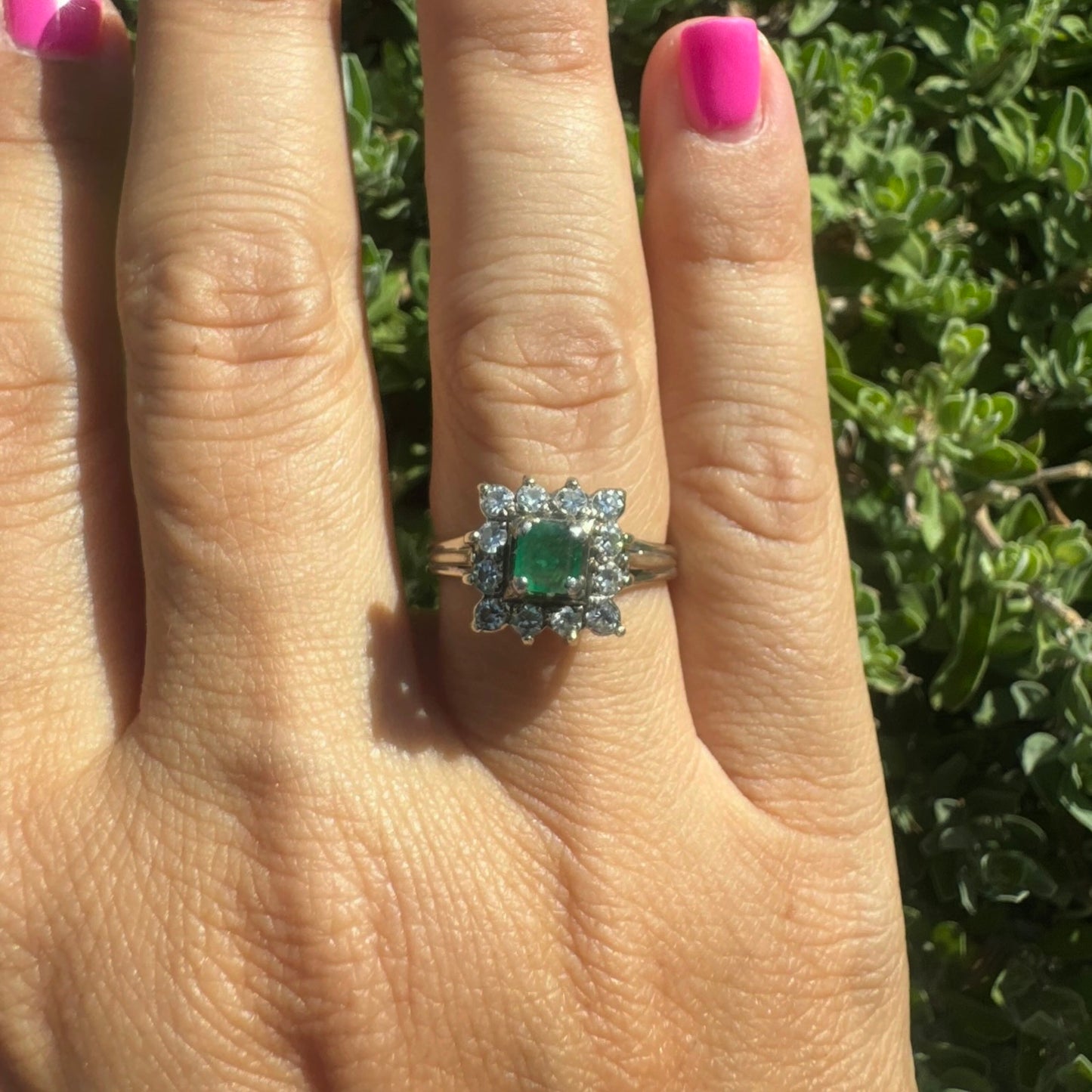 18K gold ring set with a vibrant square-cut Emerald surrounded by a sparkling halo of Diamonds.