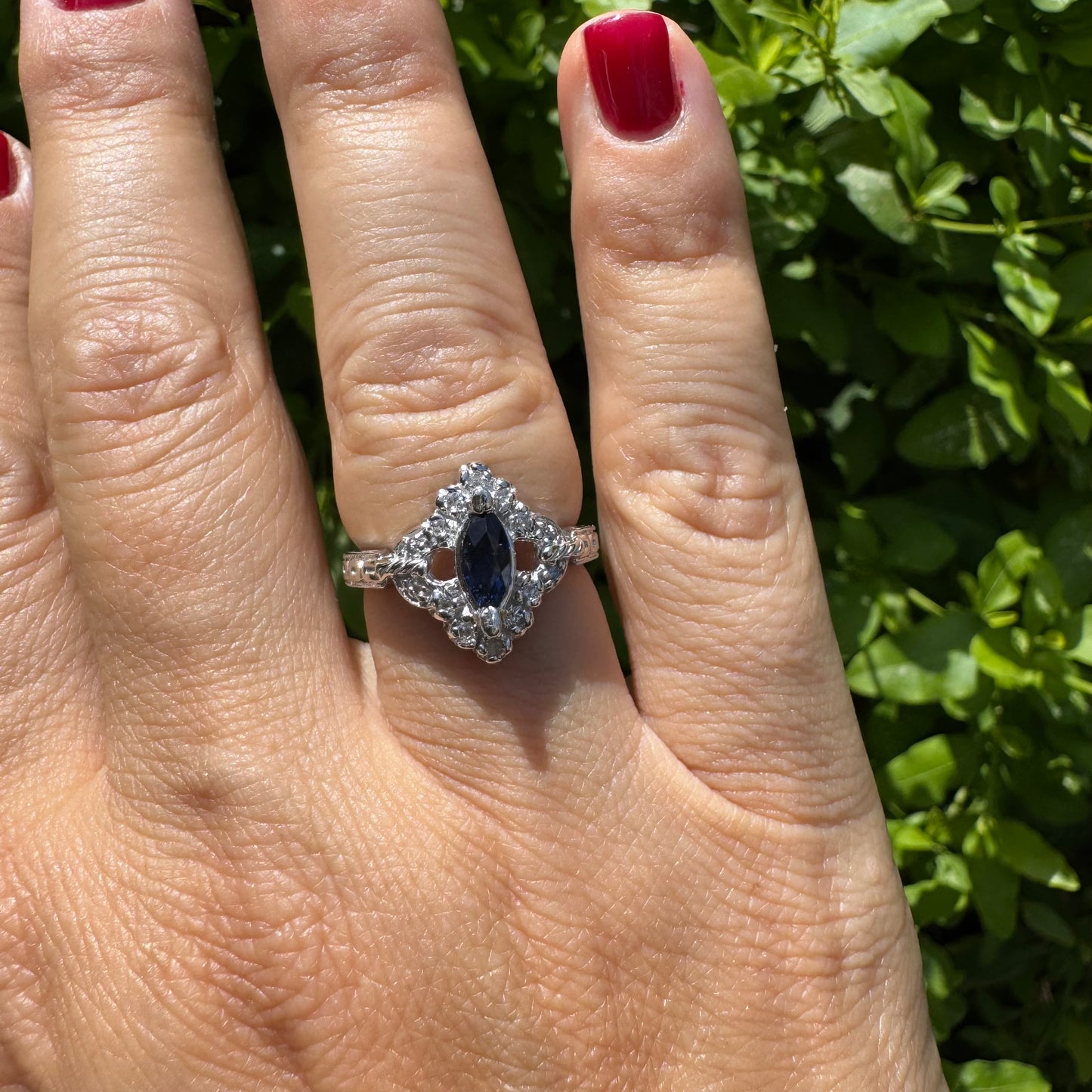 14K gold ring set with a marquise-cut Sapphire at its center, framed by an intricate halo of sparkling Diamonds